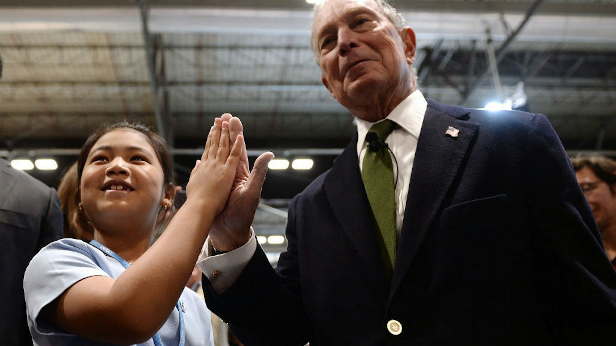 Child environmental activist from India, Licypriya Kangujam (L) and Democratic presidential hopeful Michael Bloomberg slap hands during the UN Climate Change Conference COP25 at the 'IFEMA - Feria de Madrid' exhibition centre, in Madrid, on December 10, 2019. - UN climate negotiations in Madrid remained bogged down yesterday in the fine print of the Paris treaty rulebook, out-of-sync with a world demanding action to forestall the ravages of global warming. The 196-nation talks should kick into high-gear today with the arrival of ministers, but on the most crucial issue of all -- slashing the greenhouse gas emissions overheating the planet -- major emitters have made it clear they have nothing to say. (Photo by CRISTINA QUICLER / AFP)