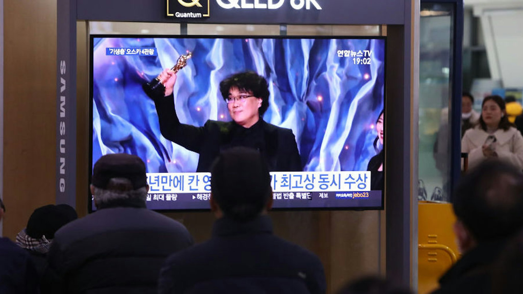 People watch a TV screen showing images of South Korean director Bong Joon Ho at the Seoul Railway Station on February 10, 2020 in Seoul, South Korea. Bong Joon-ho's "Parasite" has bagged four Oscar titles, becoming the first non-English language film to win best picture. (Photo by Chung Sung-Jun/Getty Images)