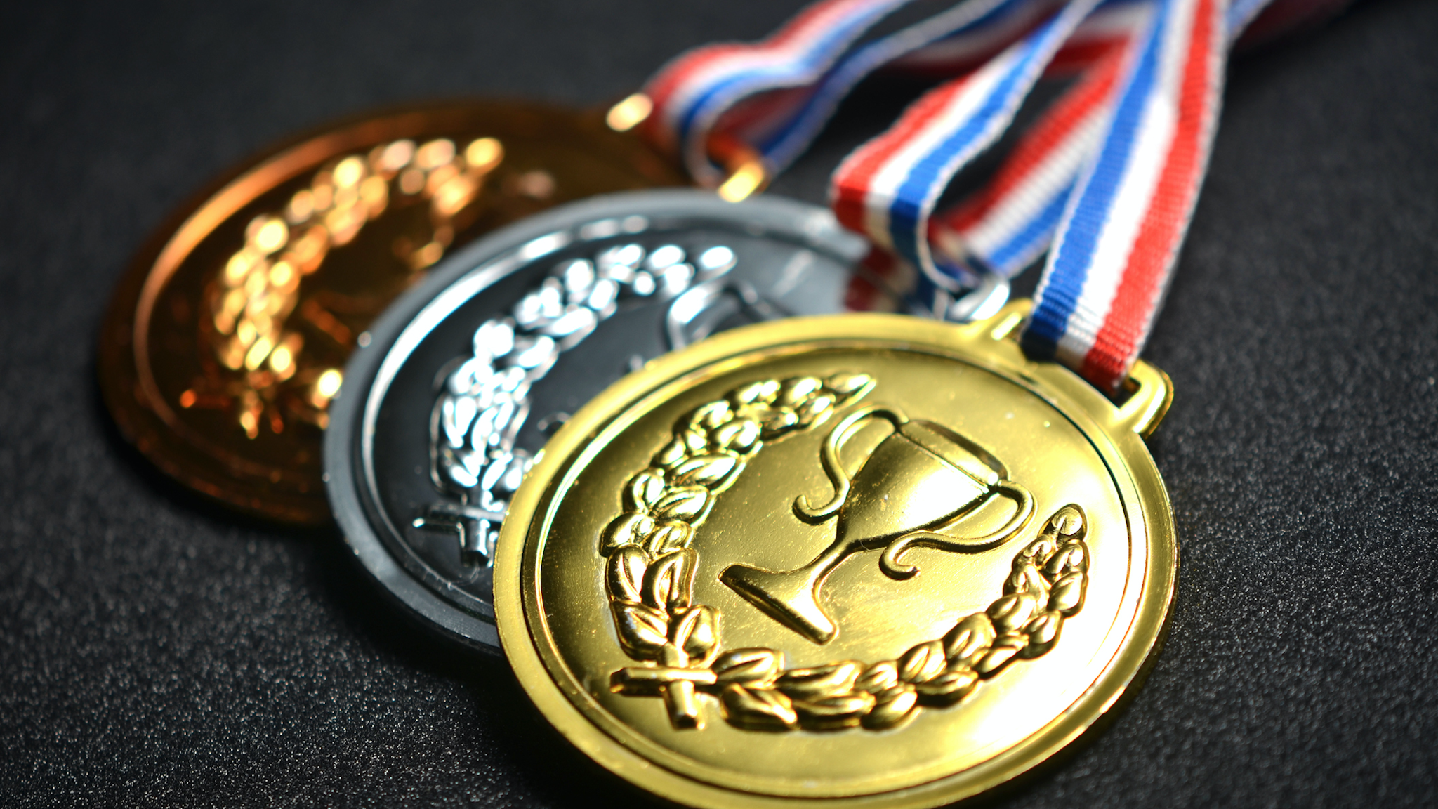 Close-Up Of Medals On Black Table - stock photo