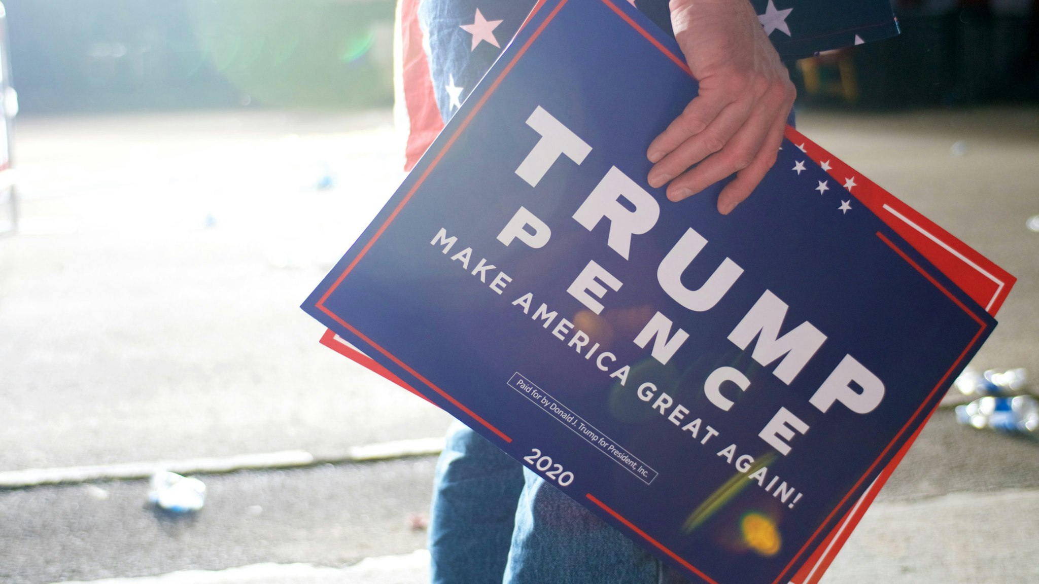 A supporters stands signs as US President Donald J Trump departs after speaking at a MAGA rally at the Williamsport Regional Airport, in Montoursville, PA on May 20, 2019.