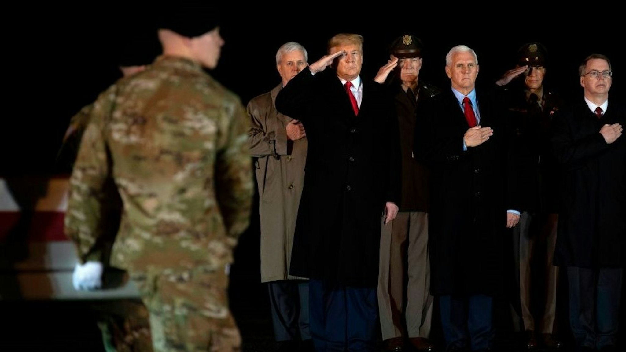 US President Donald Trump (L) and Vice President Mike Pence (C) observe the dignified transfer of two US soldiers, killed in Afghanistan, at Dover Air Force Base in Dover, Delaware, on February 10, 2020 with . - The two soldiers have been identified as Sgt. 1st Class Javier Jaguar Gutierrez, 28, of San Antonio, TX, and Sgt. 1st Class Anonio Rey Rodriguez, 28, of Las Cruces, New Mexico. US and Afghan troops came under "direct fire" in eastern Afghanistan late on February 8, a US military official said. (Photo by JIM WATSON / AFP) (Photo by