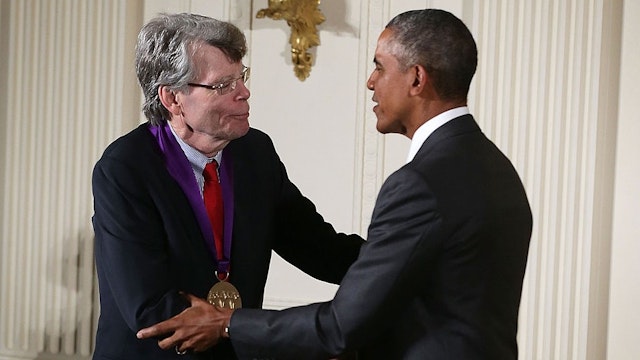 U.S. President Barack Obama (R) presents the 2014 National Medal of Arts to Stephen King (L) during an East Room ceremony at the White House September 10, 2015 in Washington, DC. Stephen King was honored for his contributions as an author.