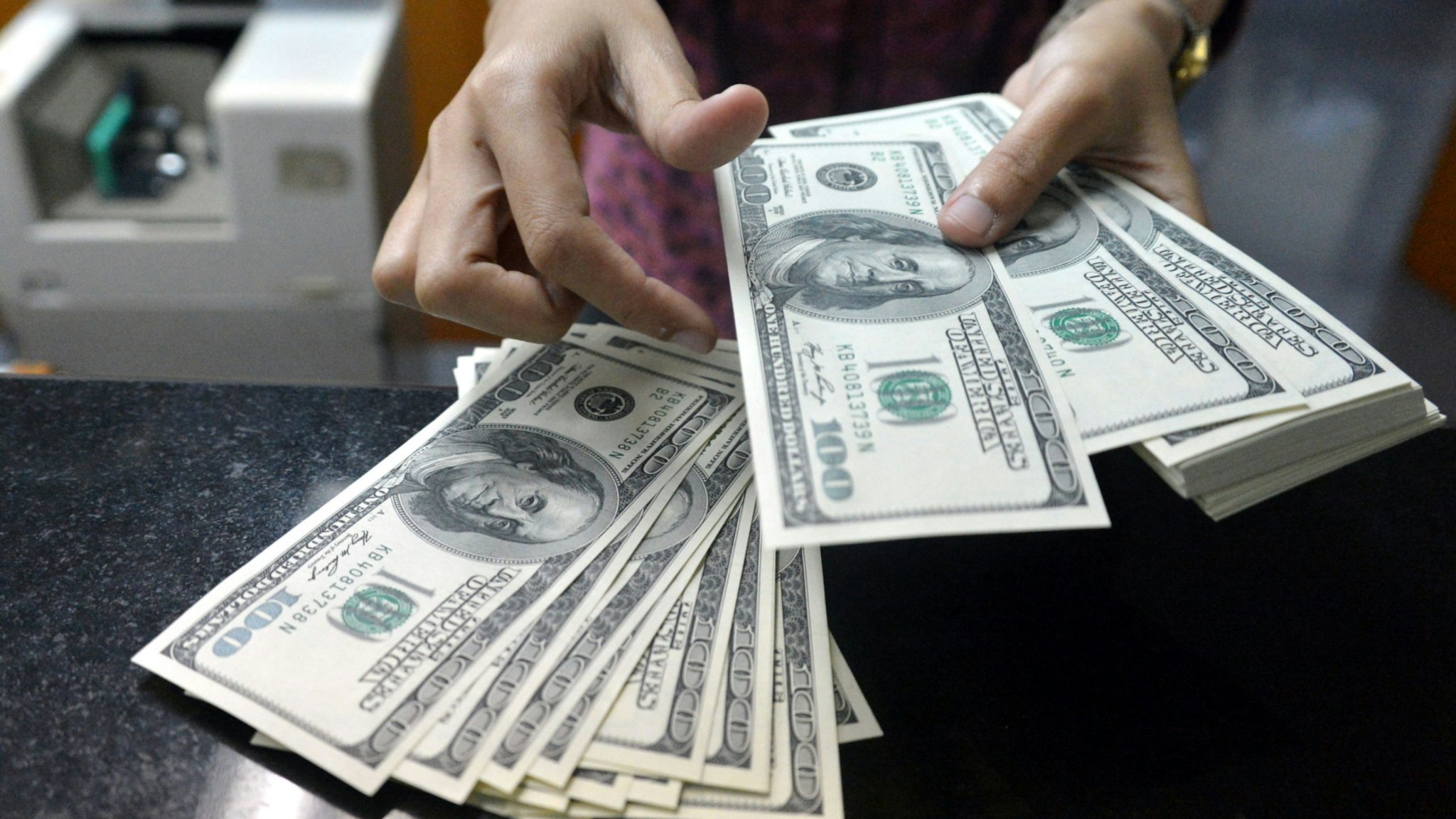 An employee counts USD notes at a money change outlet in Jakarta on June 14, 2013.
