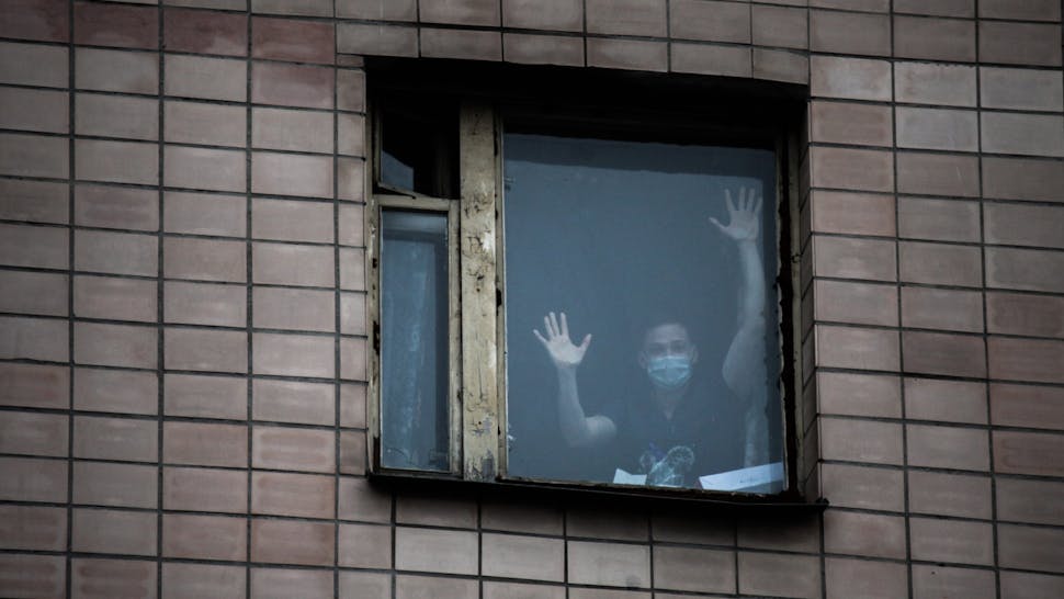 Quarantined person Student in a protective mask in the window of the quarantine building of educational premises and a hostel of the St. Petersburg Medical Academy in St. Petersburg The building is quarantined after the coronavirus was detected in a student who returned from Italy. 05 march 2020.