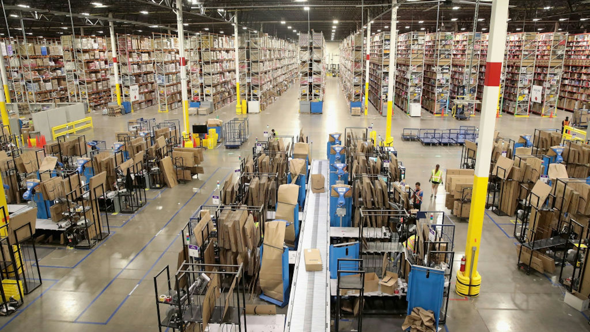 ROMEOVILLE, IL - AUGUST 01: Workers pack and ship customer orders at the 750,000-square-foot Amazon fulfillment center on August 1, 2017 in Romeoville, Illinois. On August 2, Amazon will be holding job fairs at several fulfillment centers around the country, including the Romeoville facility, in an attempt to hire more than 50,000 workers.