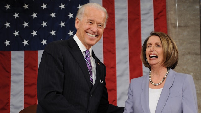 US Vice-President Joe Biden (L) and Speaker of the House Nancy Pelosi shake hands as President Barack Obama enters the room to deliver his first State of the Union speech to a joint session of Congress in Washington on January 27, 2010.