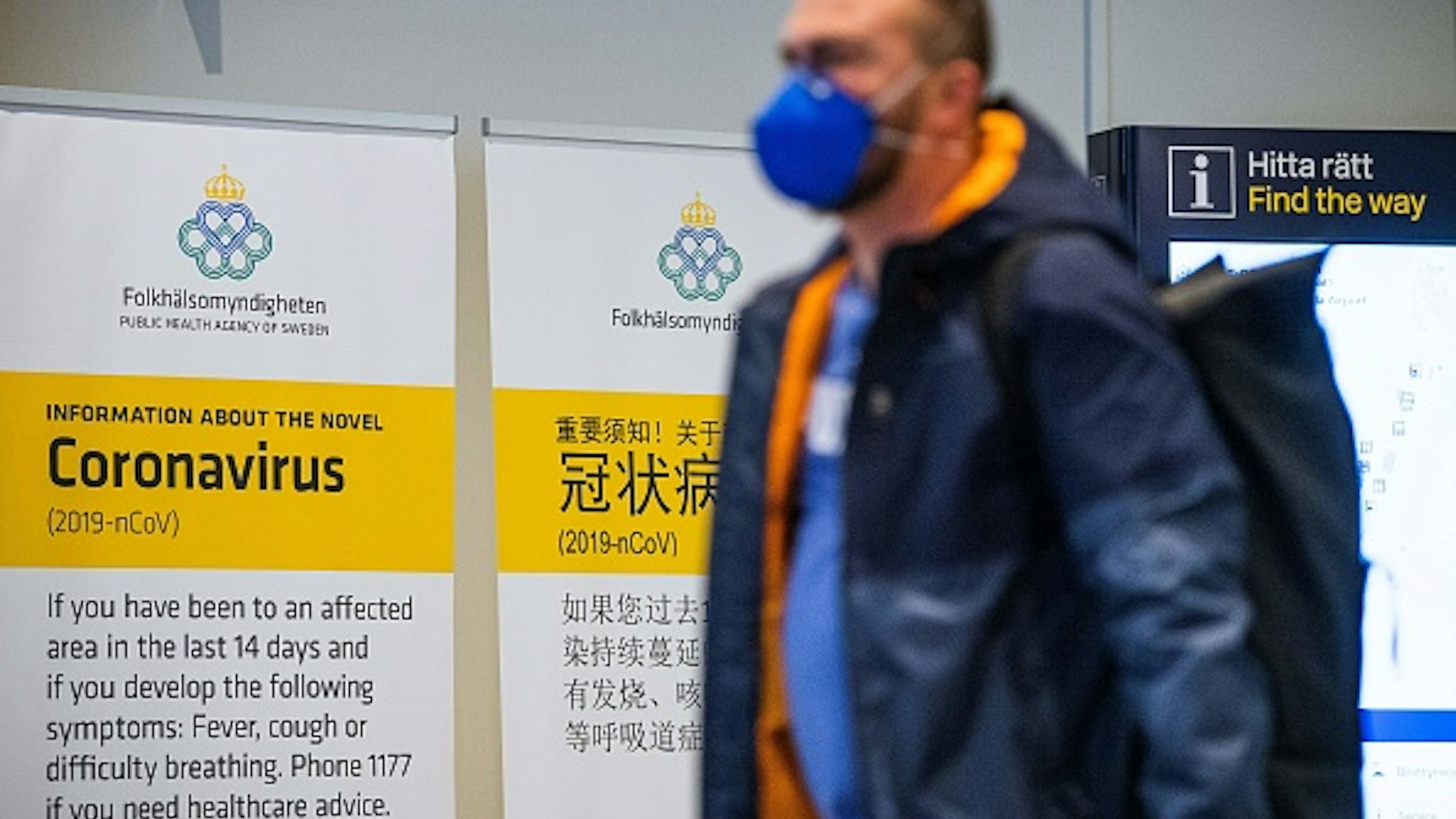 A passenger arriving in Stockholm's Arlanda airport is greeted by signs produced by the public health agency advising travelers what to do if they show symptoms of infection by the new coronavirus after arriving in Sweden on March 5, 2020.