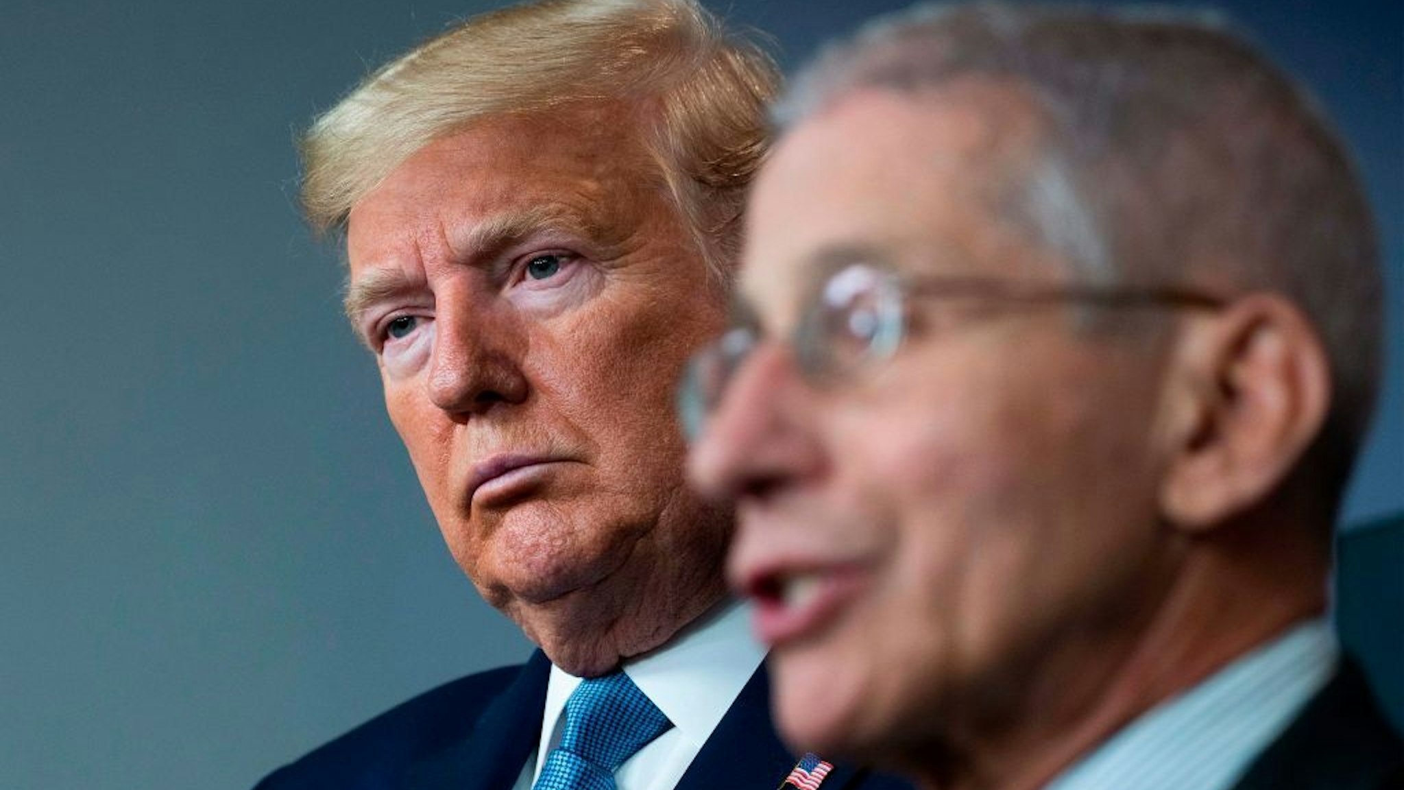 US President Donald Trump listens as National Institute of Allergy and Infectious Diseases Director, Dr. Anthony Fauci, speaks during the daily briefing on the novel coronavirus, COVID-19, at the White House on March 21, 2020, in Washington, DC. (Photo by JIM WATSON / AFP)