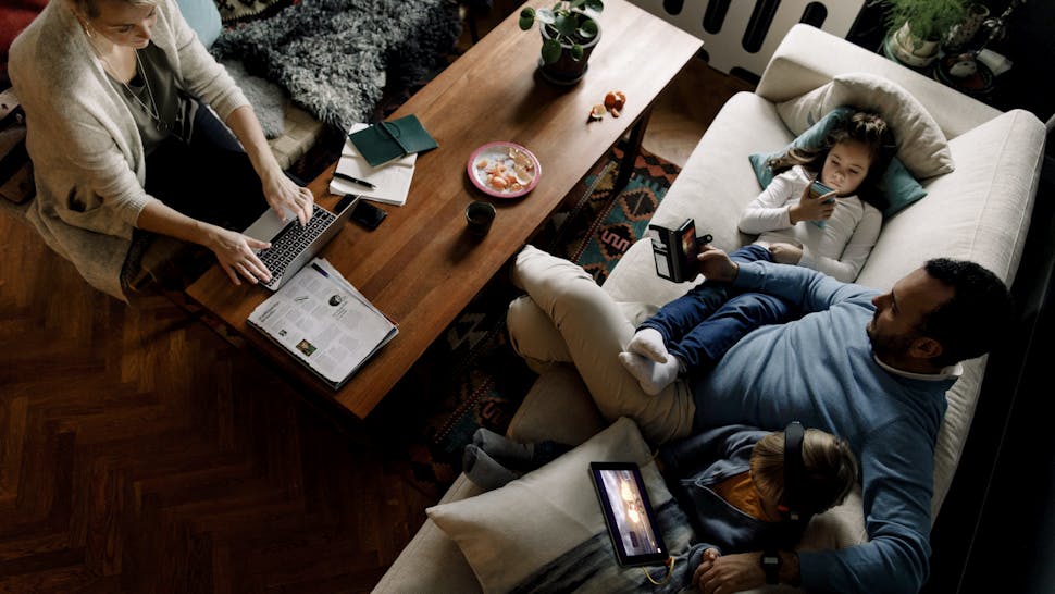 High angle view of family using various technologies in living room at home High angle view of family using various technologies in living room at home
