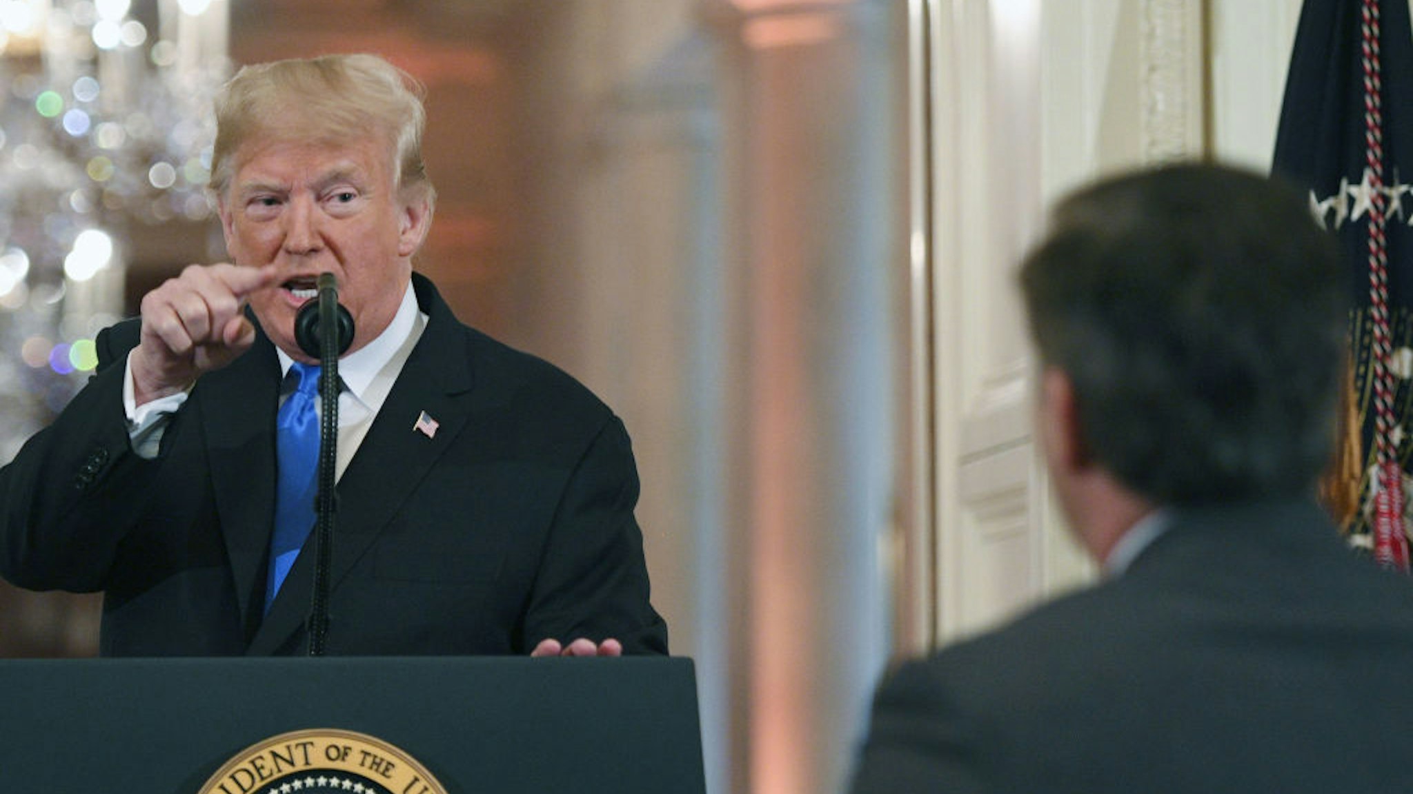 President Donald Trump points to journalist Jim Acosta