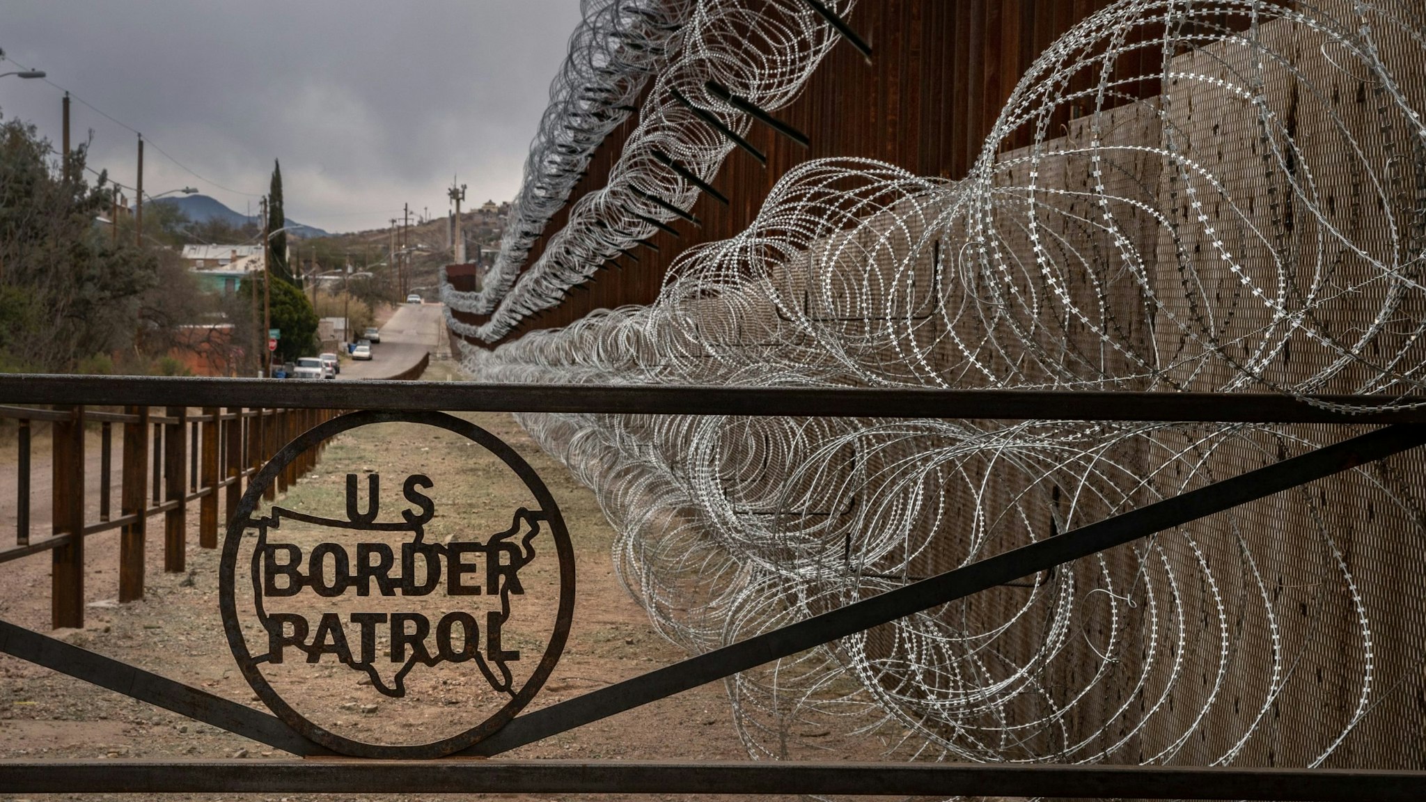 TOPSHOT - A metal fence marked with the US Border Patrol sign prevents people to get close to the barbed/concertina wire covering the US/Mexico border fence, in Nogales, Arizona, on February 9, 2019. (Photo by Ariana Drehsler / AFP) (Photo credit should read ARIANA DREHSLER/AFP via Getty Images)