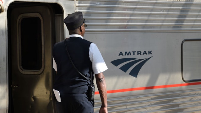 An Amtrak train conductor prepares to signal the engineer prior to departing from Union Station in downtown Denver, Colorado.