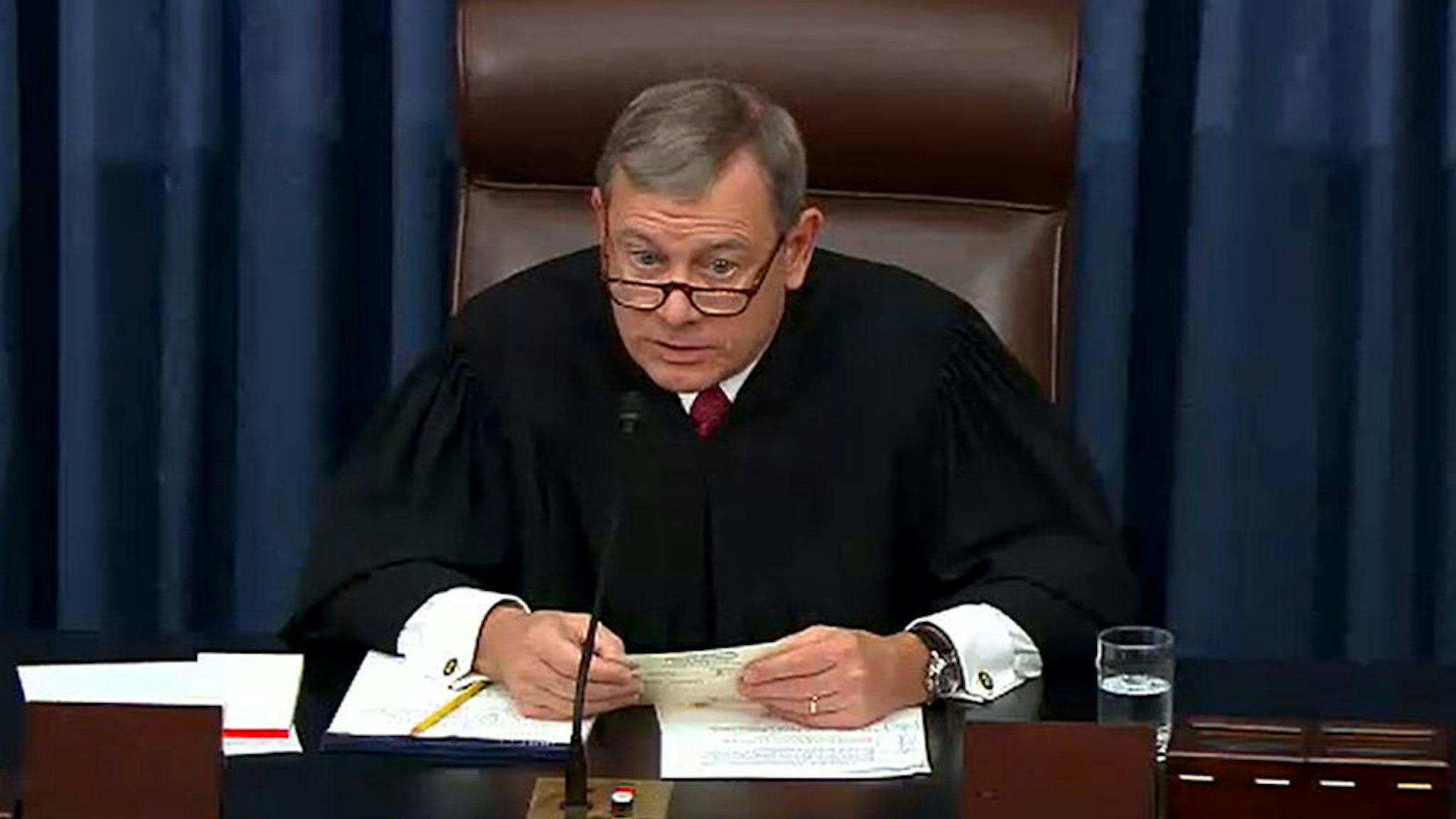 In this screengrab taken from a Senate Television webcast, Chief Justice John Roberts reads a question from a senator during impeachment proceedings against U.S. President Donald Trump in the Senate at the U.S. Capitol on January 29, 2020 in Washington, DC.