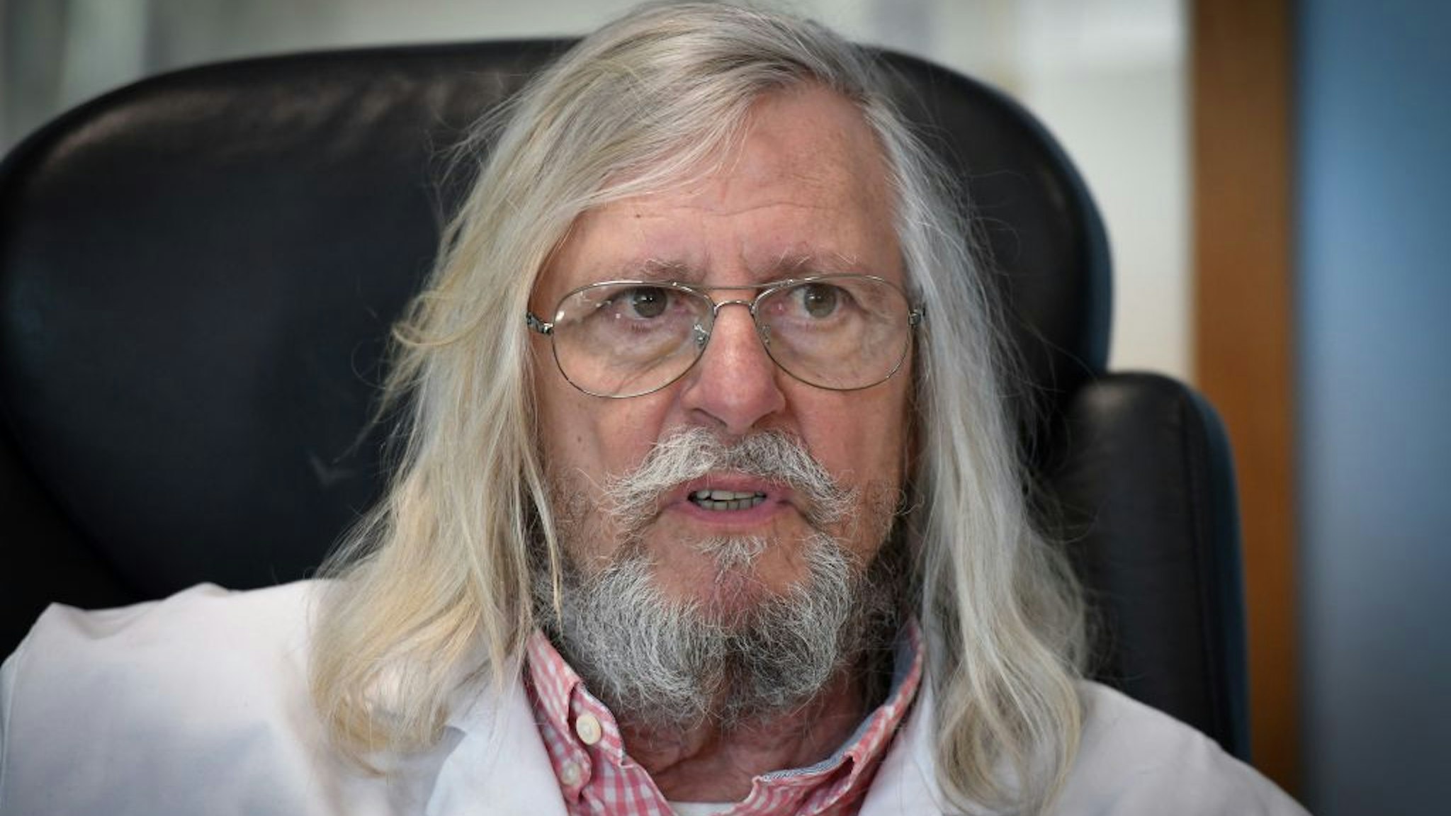 A picture taken on February 26, 2020 shows French professor Didier Raoult, biologist and professor of microbiology, specialized in infectious diseases and director of IHU Mediterranee Infection Institute posing in his office in Marseille, southeastern France.