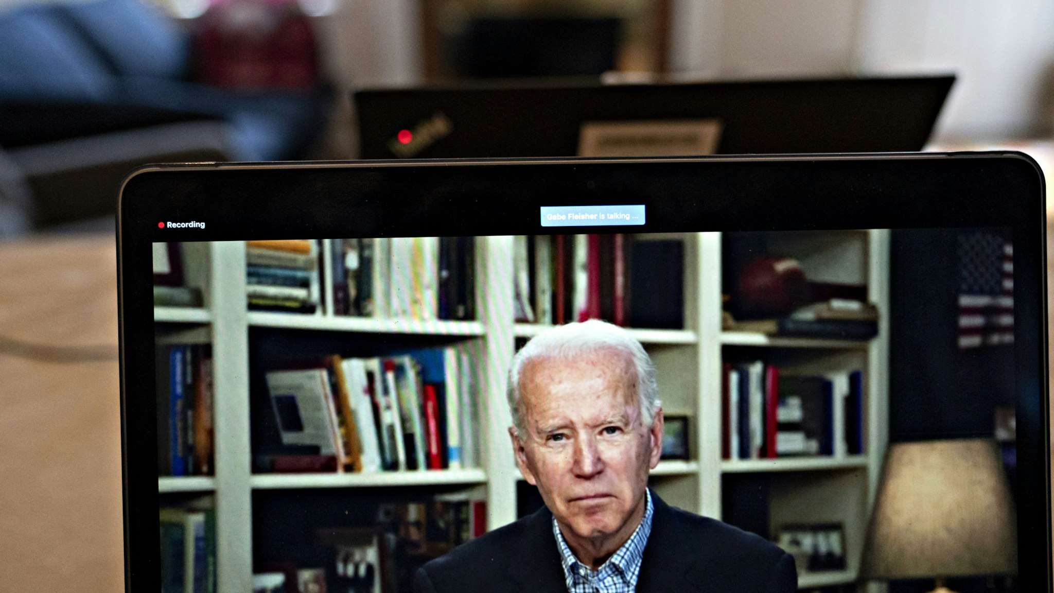 Former Vice President Joe Biden, 2020 Democratic presidential candidate, listens to a question during a virtual press briefing on a laptop computer in this arranged photograph in Arlington, Virginia, U.S., on Wednesday, March 25, 2020. During the livestreamed news conference today, Biden said he didn't see the need for another debate, which the Democratic National Committee had previously said would happen sometime in April. Photographer: Andrew Harrer/Bloomberg via Getty Images