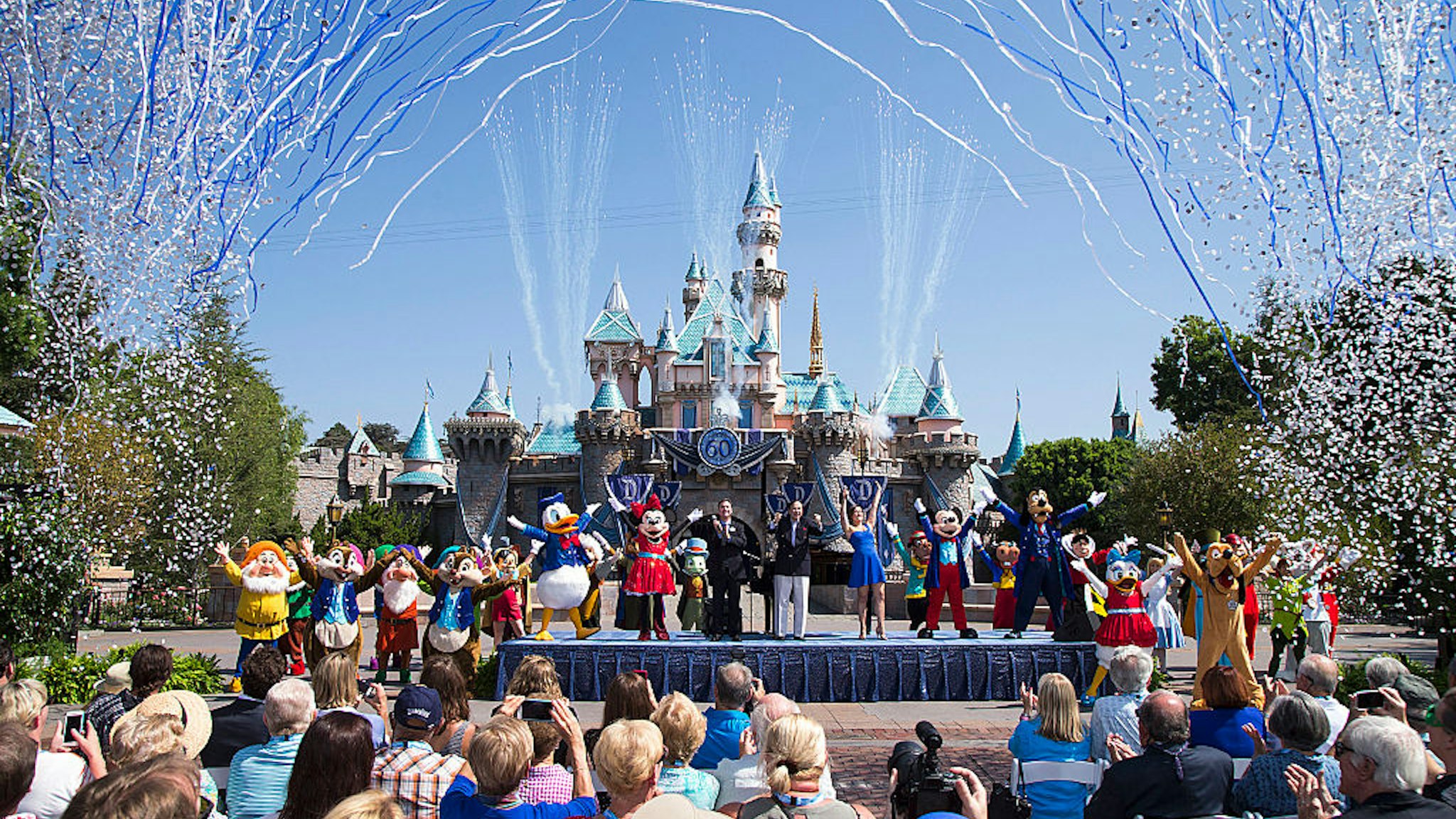 In this handout photo provided by Disney parks, Mickey Mouse and his friends celebrate the 60th anniversary of Disneyland park during a ceremony at Sleeping Beauty Castle featuring Academy Award-winning composer, Richard Sherman and Broadway actress and singer Ashley Brown July 17, 2015 in Anaheim, California.