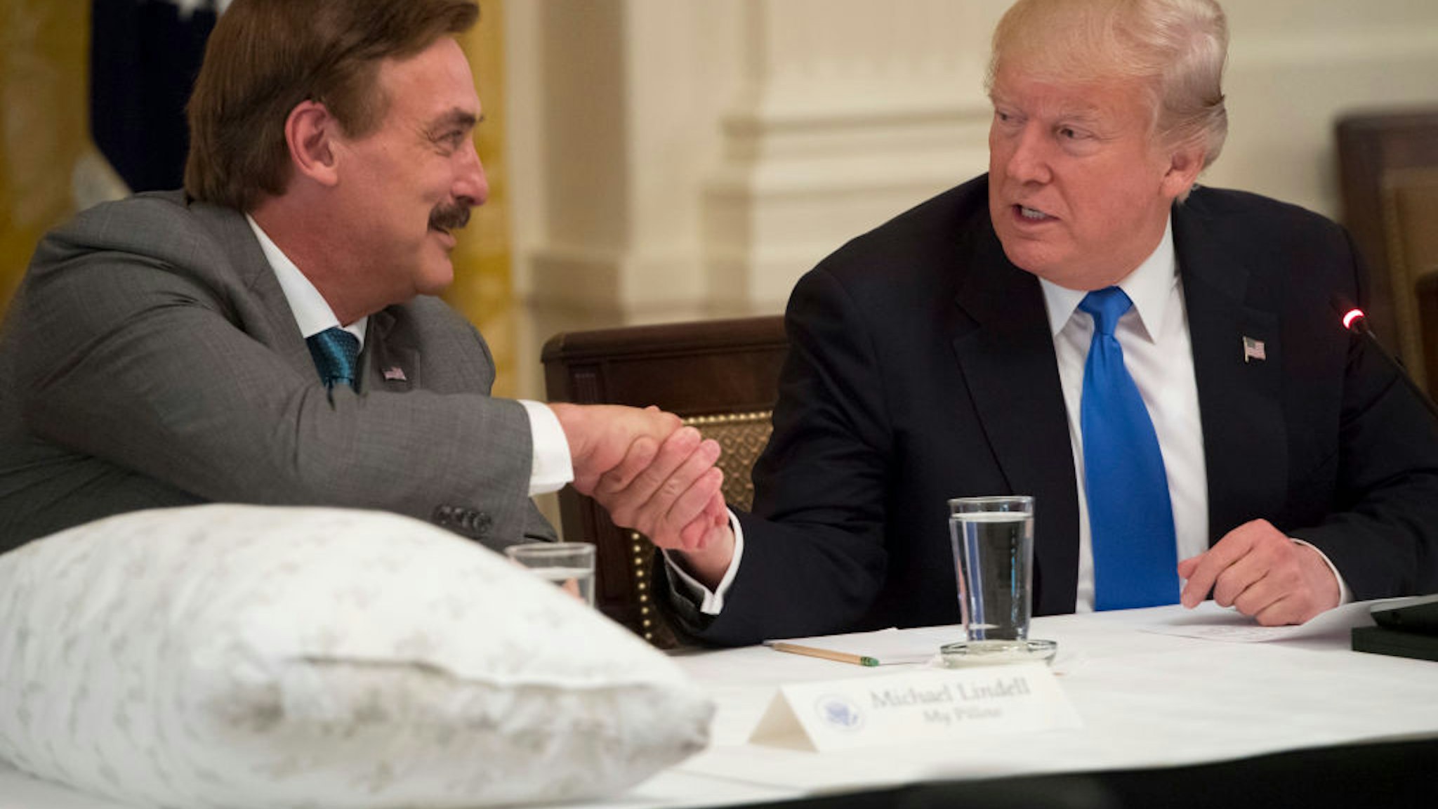 US President Donald Trump shakes hands with Mike Lindell