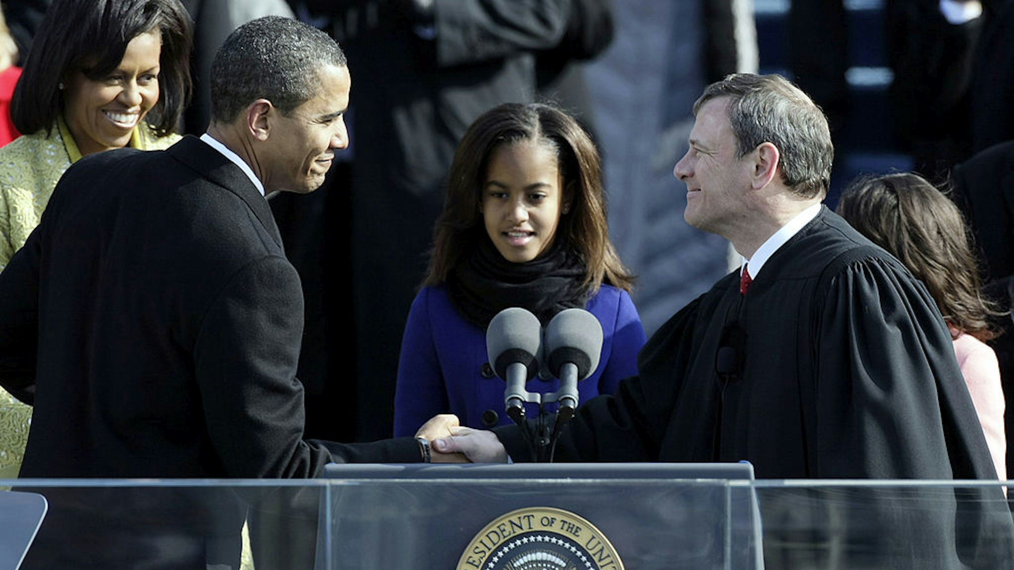 Barack H. Obama shakes the hand of Chief Justice John Roberts after his swearing in as the 44th president of the United Statesas on the West Front of the Capitol as his wife Michelle looks on January 20, 2009 in Washington, DC.