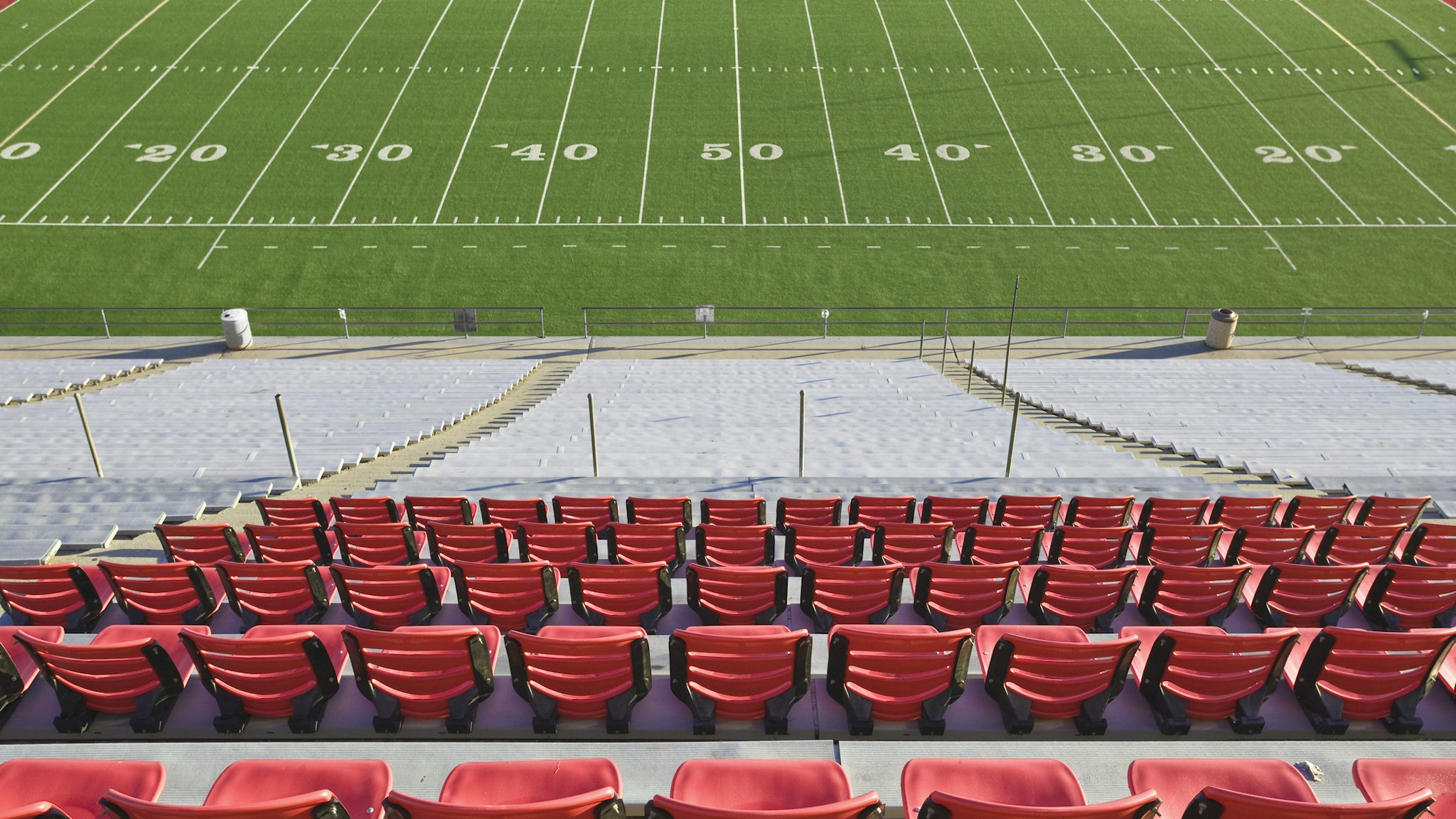 Empty football field and stadium seats. - stock photo