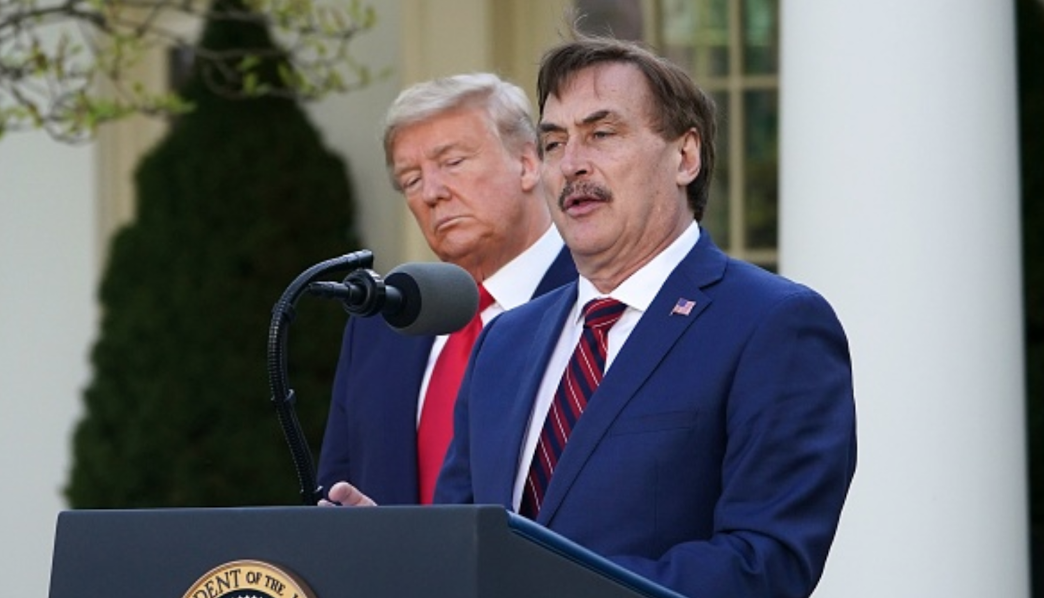 US President Donald Trump listens as Michael J. Lindell, CEO of MyPillow Inc., speaks during the daily briefing on the novel coronavirus, COVID-19, in the Rose Garden of the White House in Washington, DC, on March 30, 2020.