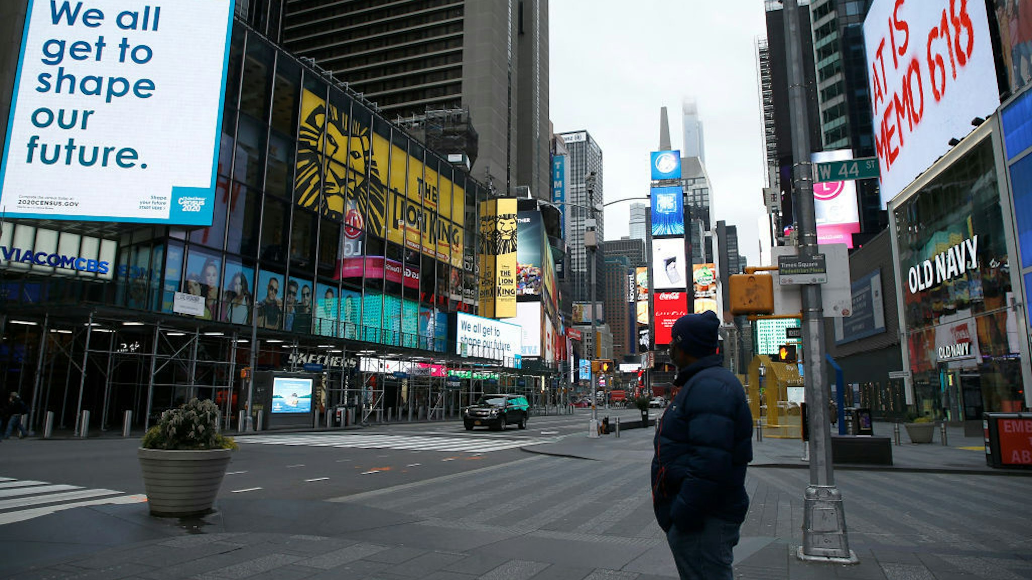 A man takes in the atmosphere in a mostly empty Times Square, New York, US, on March 25, 2020. (Photo by John Lamparski/NurPhoto via Getty Images)