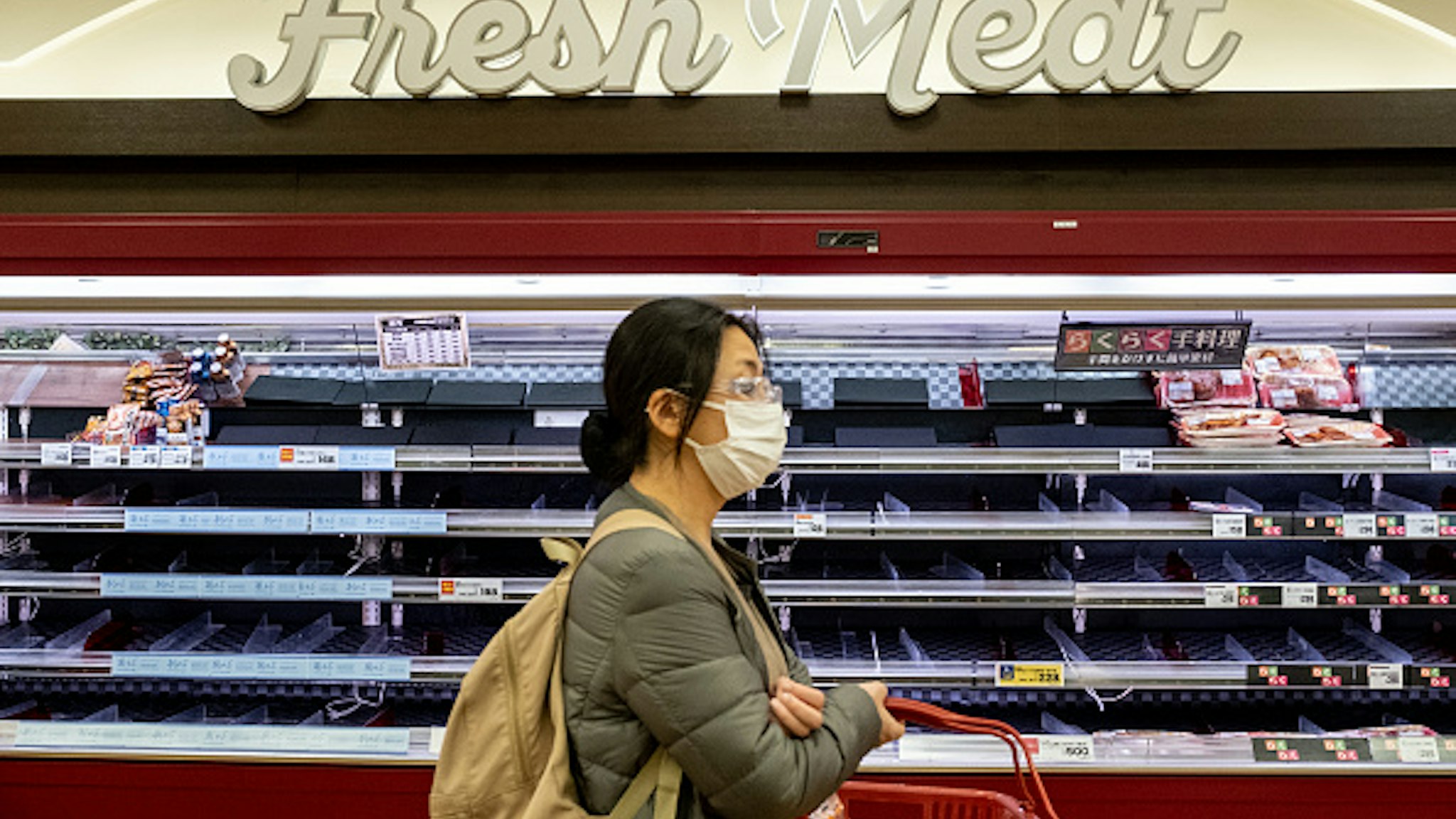 TOKYO, JAPAN - MARCH 27, 2020: A woman wearing a face mask as a precaution against the spread of Coronavirus seen shopping after the Tokyo Local Government have asked citizen to stay home and do not go out unless necessary this coming weekend. Concerns are growing about the increasing cases of Coronavirus (COVID-19) in Japan. Many countries have closed borders to Japan and the growing pandemic has caught public attention on the true number of coronavirus cases in Japan that could be much higher.