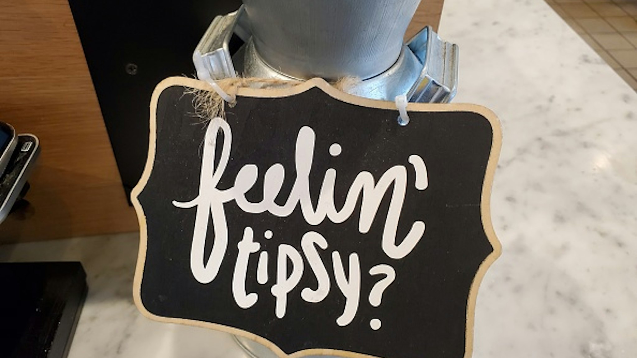Close-up of comical tip jar with sign with pun reading Feelin Tipsy at Mendocino Farms restaurant in San Ramon, California, December 9, 2019.