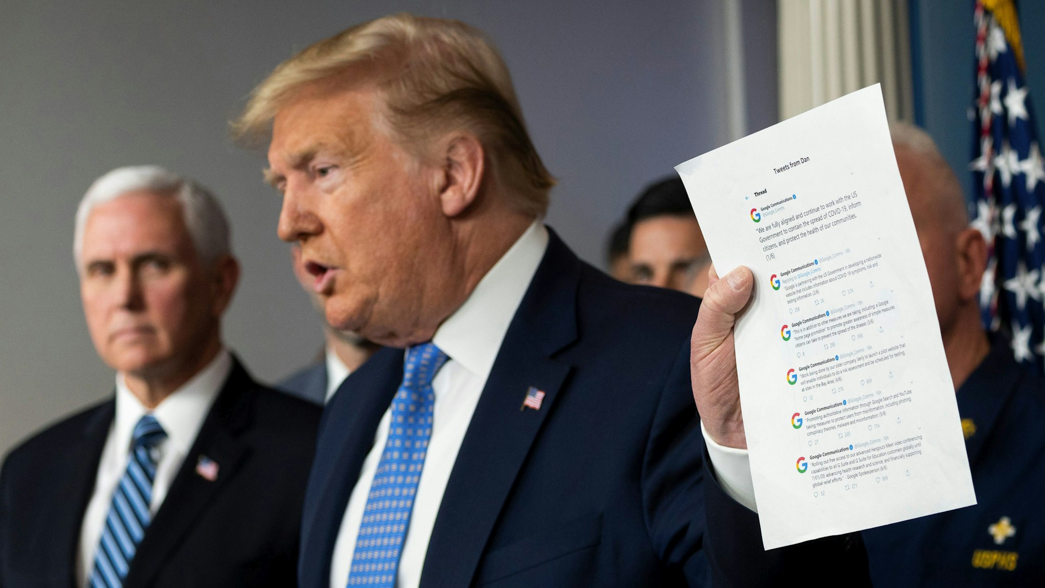 US President Donald Trump holds up tweets from Google as he speaks during a press briefing about the Coronavirus (COVID-19) alongside US Vice President Mike Pence (L) and members of the Coronavirus Task Force in the Brady Press Briefing Room at the White House in Washington, DC, March 15, 2020.