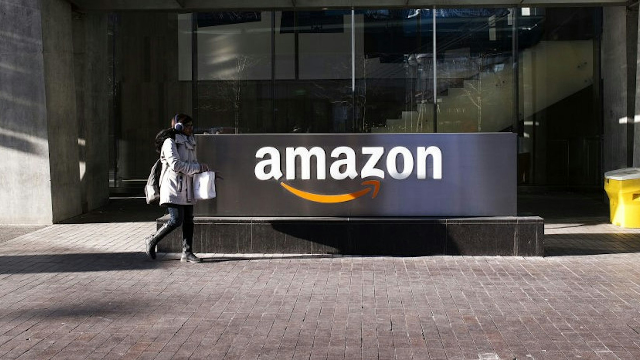 A pedestrian walks past the Amazon.com Inc. headquarters in the financial district of Toronto, Ontario, Canada, on Friday, Feb. 21, 2020. Canadian stocks declined with global markets, as authorities struggled to keep the coronavirus from spreading more widely outside China. However, investors flocking to safe havens such as gold offset the sell-off in Canada's stock market. Photographer: