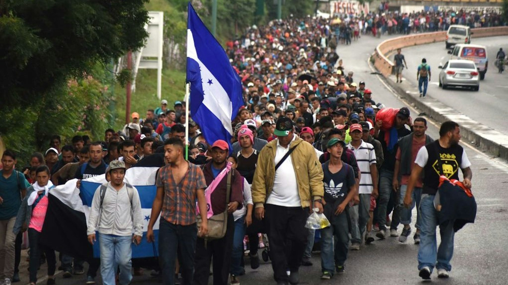 TOPSHOT - Honduran migrants take part in a caravan towards the United States in Chiquimula, Guatemala on October 17, 2018. - A migrant caravan set out on October 13 from the impoverished, violence-plagued country and was headed north on the long journey through Guatemala and Mexico to the US border. President Donald Trump warned Honduras he will cut millions of dollars in aid if the group of about 2,000 migrants is allowed to reach the United States. (Photo by ORLANDO ESTRADA / AFP) (Photo credit should read