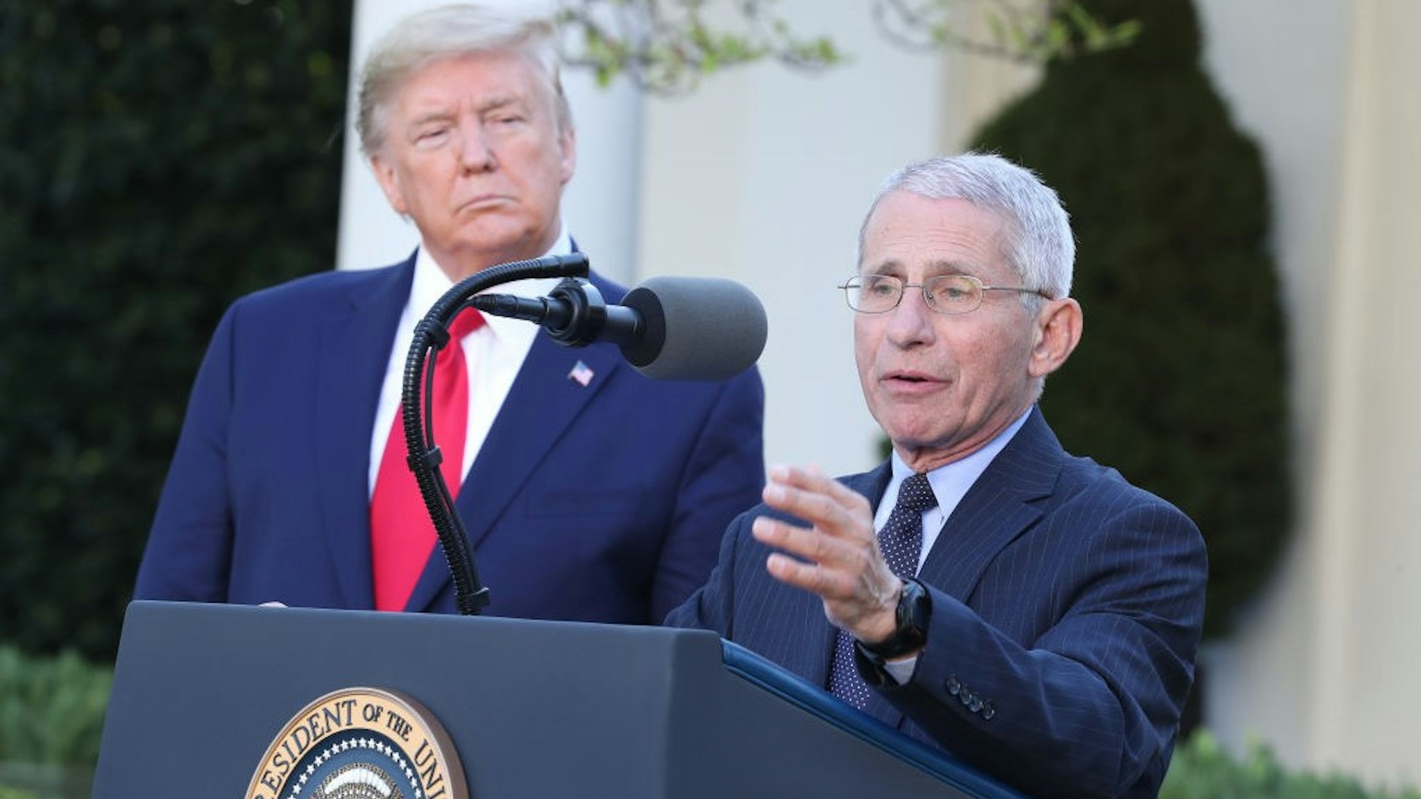 Anthony Fauci, director of the National Institute of Allergy and Infectious Diseases, right, speaks as U.S. President Donald Trump listens during a Coronavirus Task Force news conference in the Rose Garden of the White House in Washington, D.C., U.S., on Monday, March 30, 2020. Trump said he would now extend social distancing measures until at least April 30. Photographer