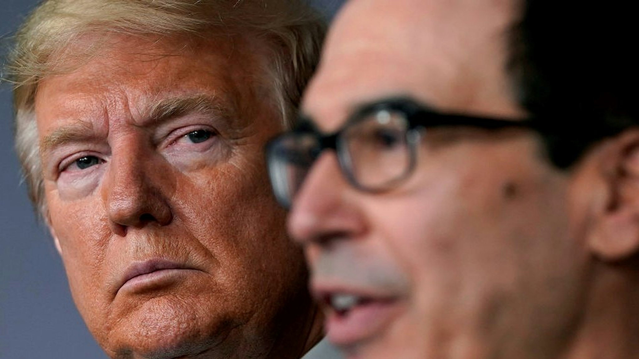 WASHINGTON, DC - MARCH 17: (L-R) U.S. President Donald Trump listens to Secretary of the Treasury Steven Mnuchin speak during a briefing about the coronavirus in the press briefing room at the White House on March 17, 2020 in Washington, DC. The Trump administration is considering an $850 billion stimulus package to counter the economic fallout as the coronavirus spreads. (Photo by