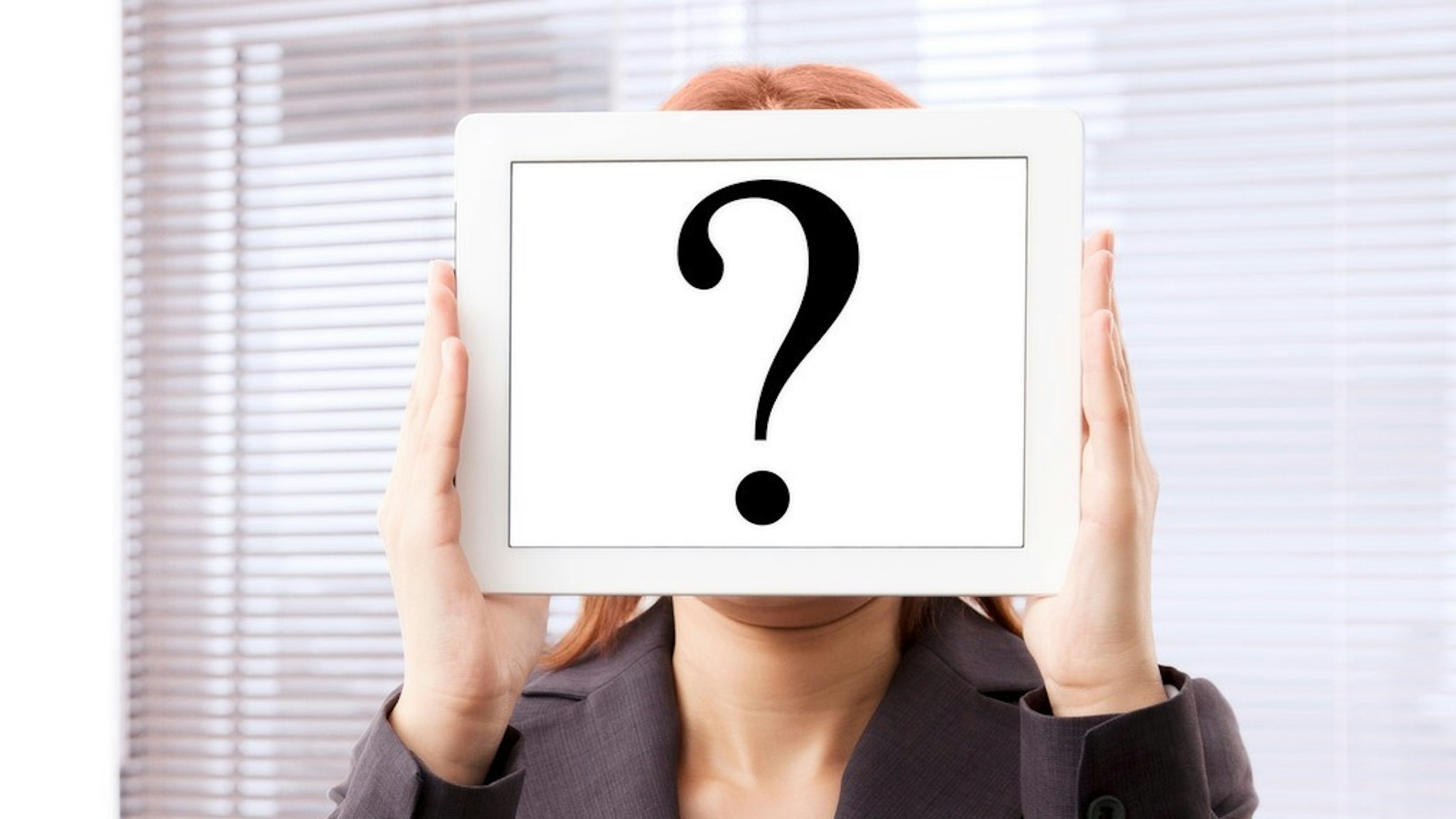 Businesswoman with question mark touchscreen tablet