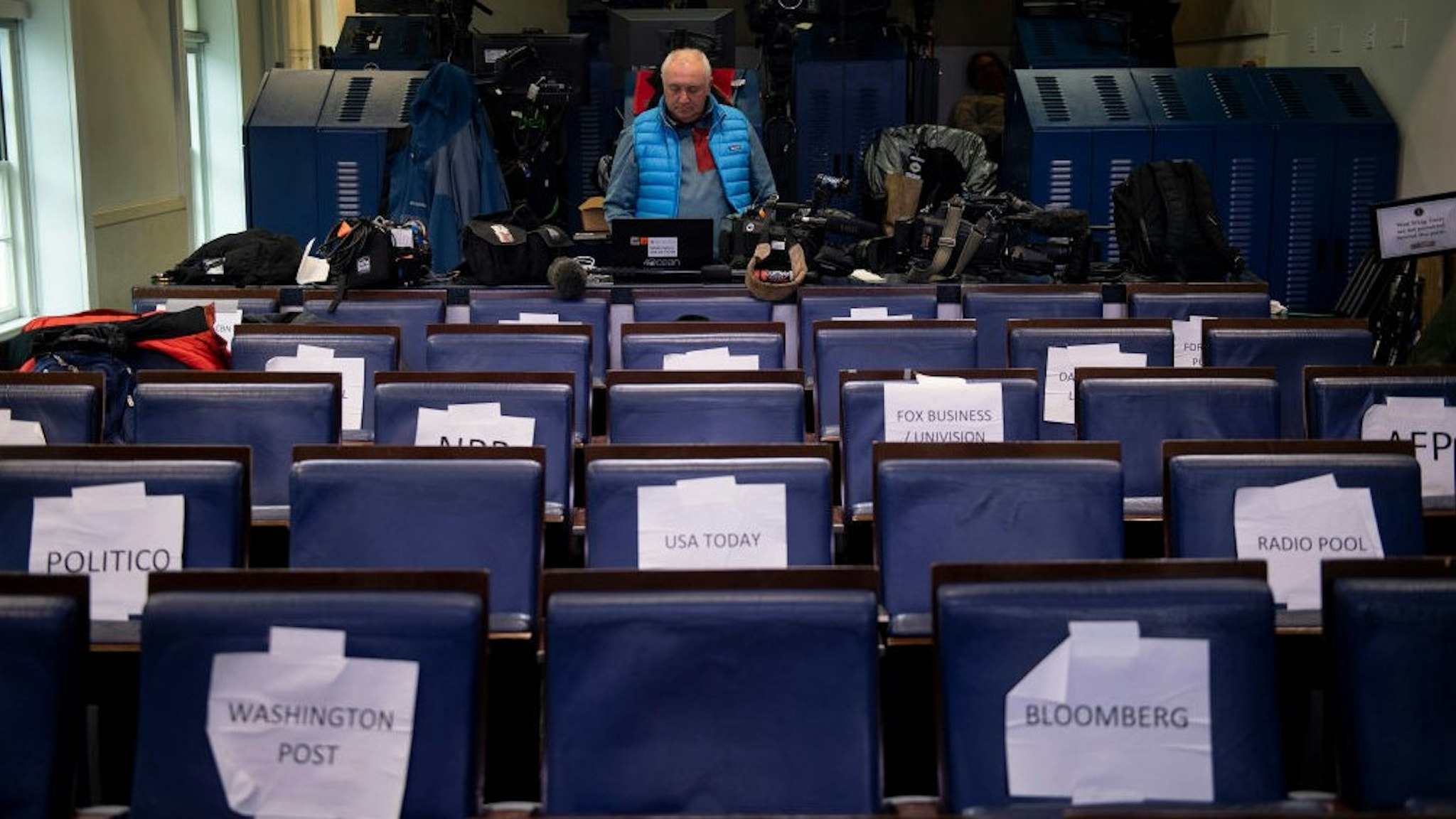 A TV journalist waits in the press briefing room of the White House March 23, 2020, in Washington, DC. (Photo by Brendan Smialowski / AFP) (Photo by