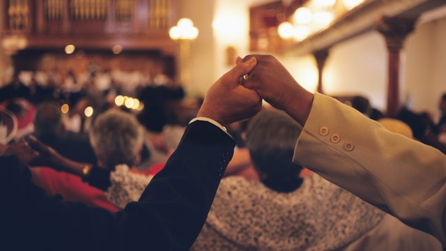 Congregation members hold hands at the Mother Bethel African Methodist Episcopal Church.