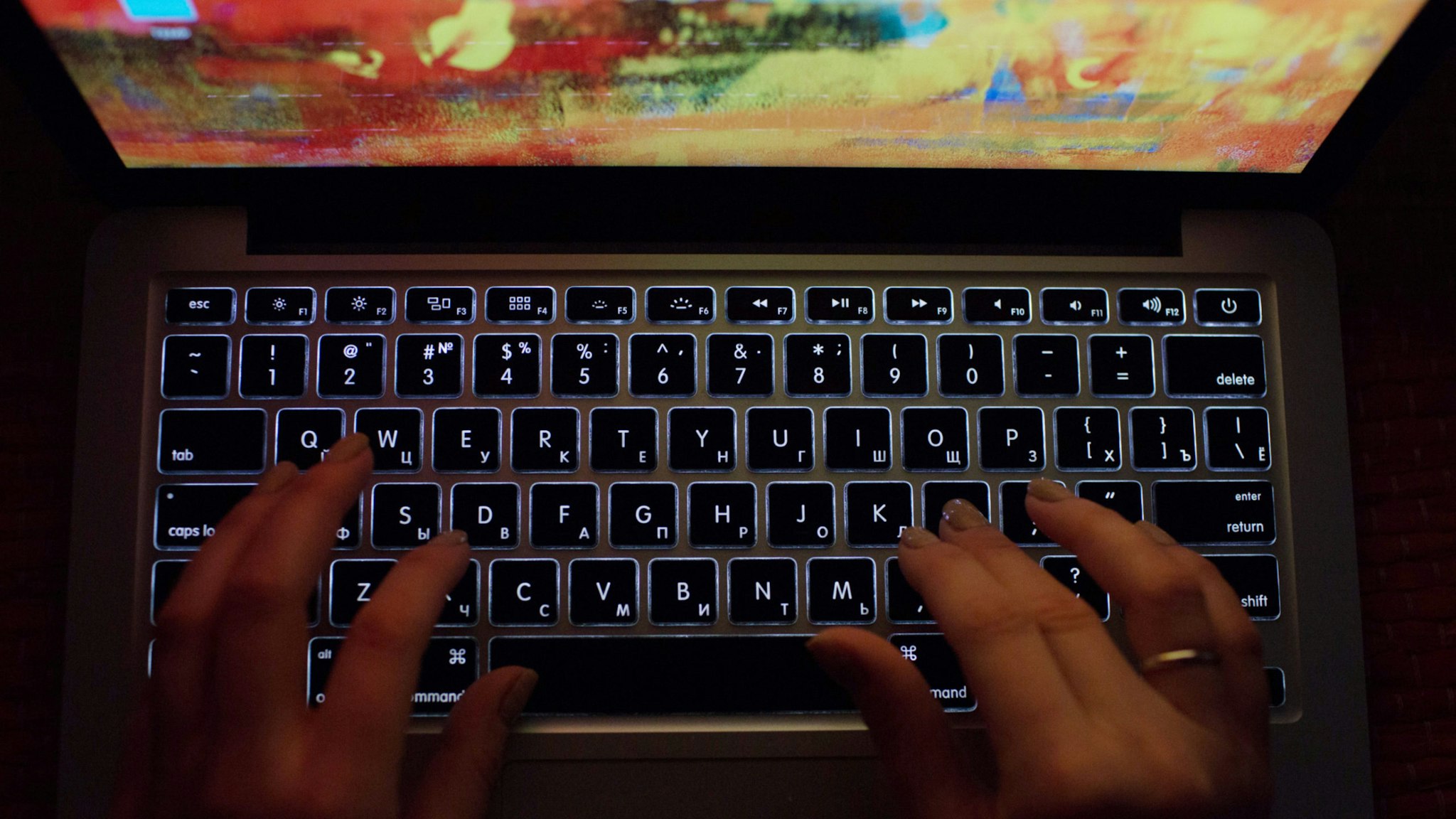A person uses a laptop computer with illuminated English and Russian Cyrillic character keys in this arranged photograph in Moscow, Russia, on Thursday, March 14, 2019.