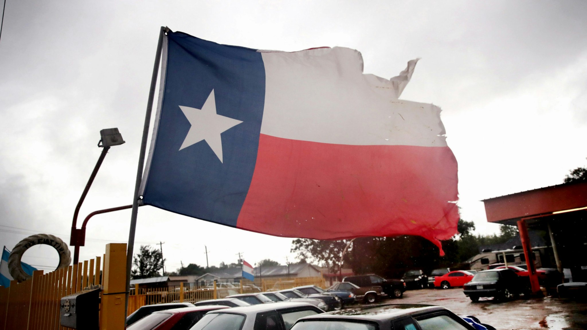 Wind from Hurricane Harvey batters a Texas flag on August 26, 2017 in Houston, Texas.