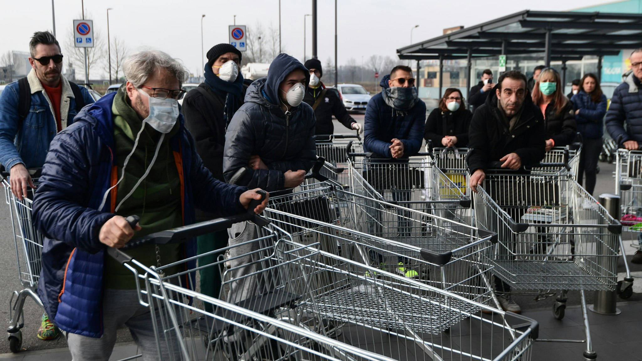Residents wait to be given access to shop in a supermarket in small groups of forty people on February 23, 2020 in the small Italian town of Casalpusterlengo, under the shadow of a new coronavirus outbreak, as Italy took drastic containment steps as worldwide fears over the epidemic spiralled.