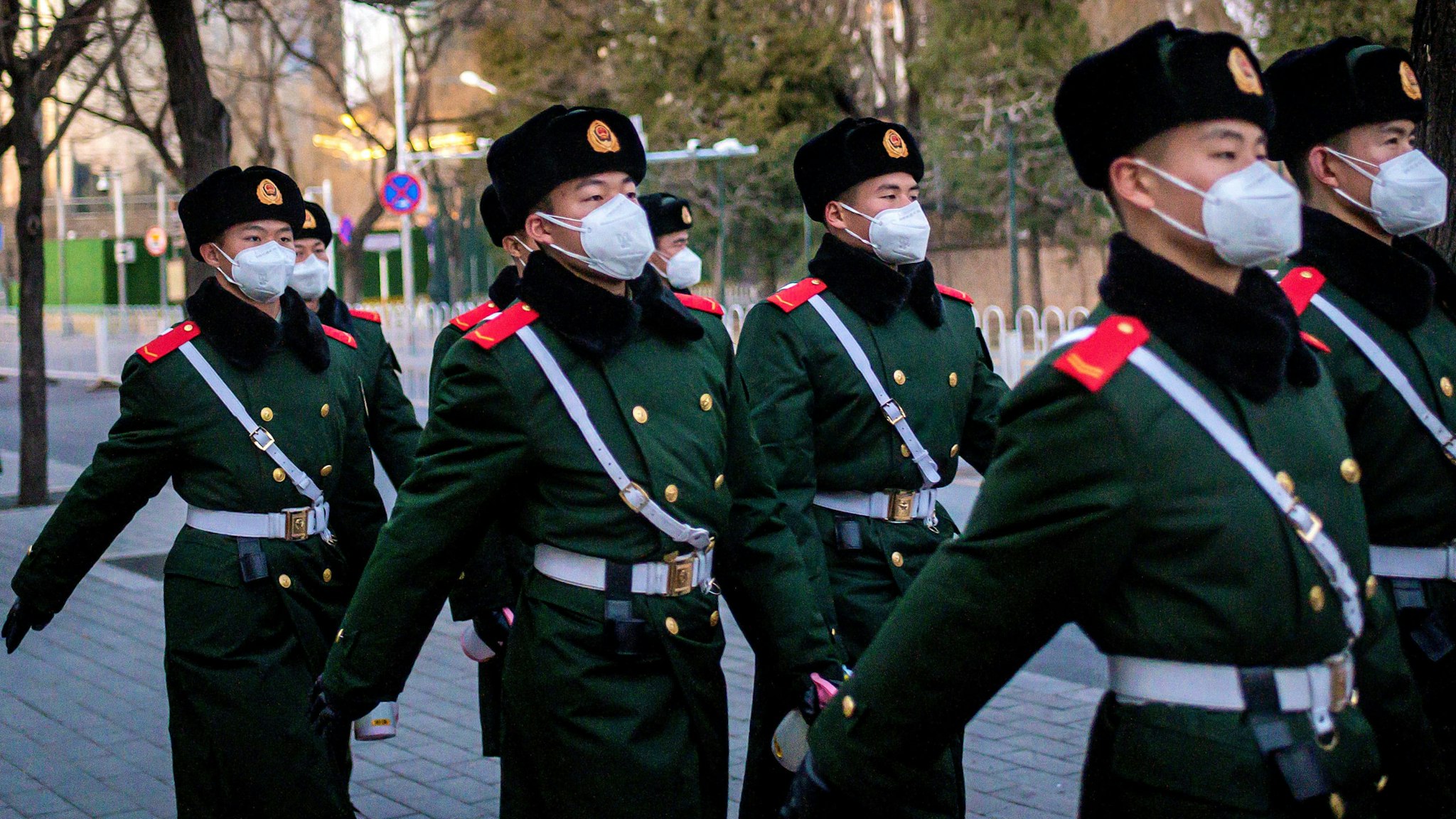 This picture taken on March 1, 2020 shows paramilitary police officers wearing face masks as they walk along a street in Beijing. - The global death toll from the new COVID-19 coronavirus epidemic surpassed 3,000 on March 2 after dozens more died at its epicentre in China and cases soared around the world, with a second fatality on US soil.