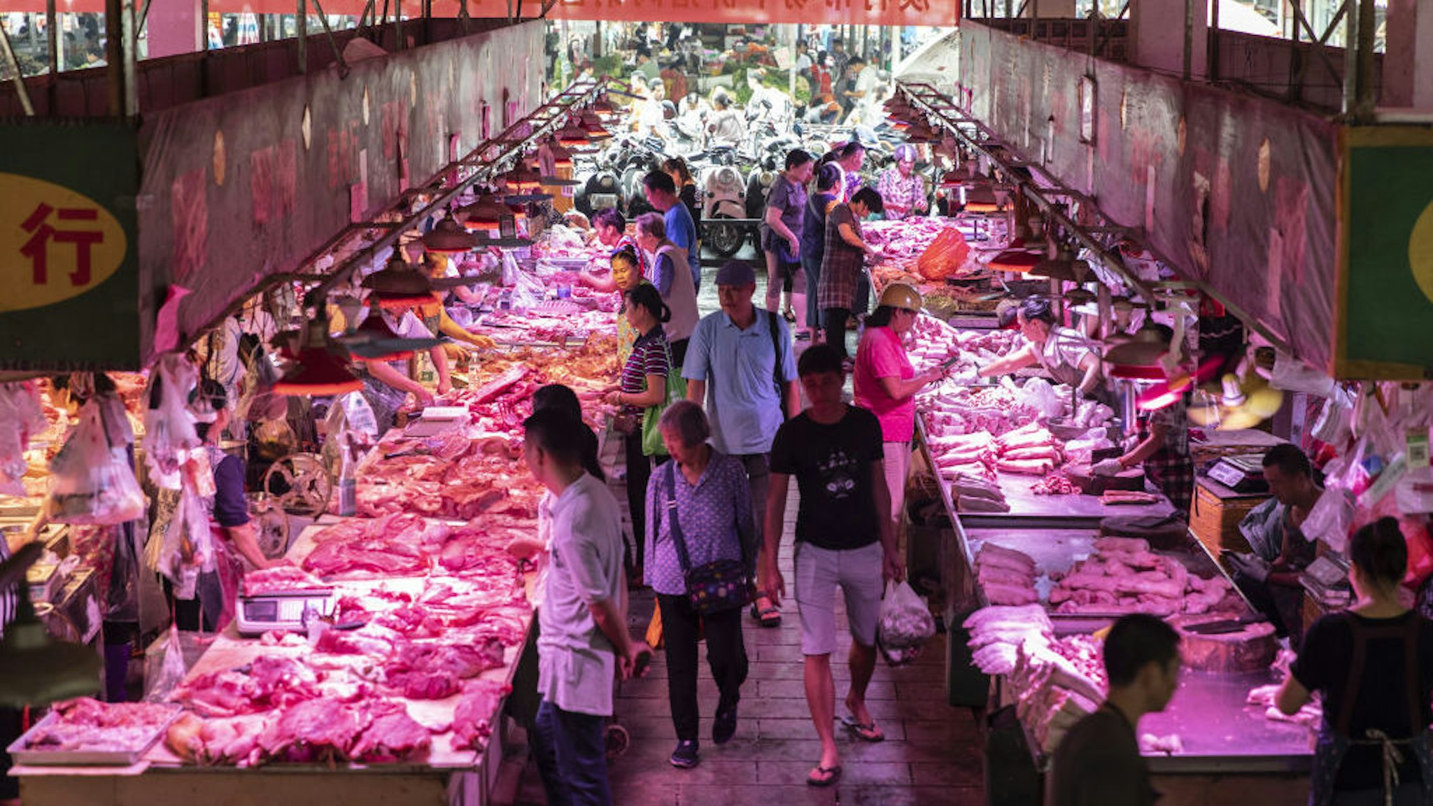 Customers walk past pork stalls at the Dancun Market in Nanning, Guangxi province, China, on Tuesday, Sept. 17, 2019. A protracted U.S. trade war, protests in Hong Kong, soaring food prices and the slowest economic growth in decades are among the many problems facing Chinese President Xi Jinping as he prepares to celebrate 70 years of Communist Party rule. Photographer: Qilai Shen/Bloomberg
