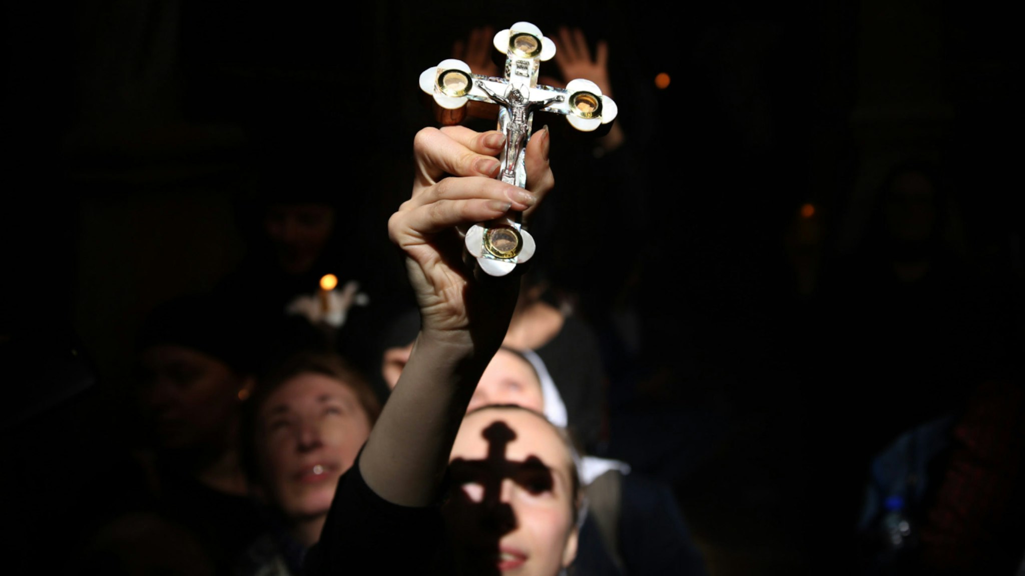 Christian Orthodox worshippers raise their heads as a ray of light comes through during the Holy Fire as thousands gather in the Church of the Holy Sepulchre in Jerusalems Old City on April 7, 2018 during the Orthodox Easter ceremony.