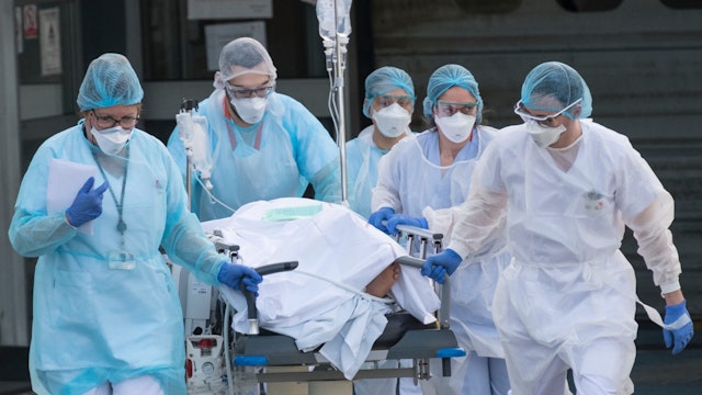 Medical staff push a patient on a gurney to a waiting medical helicopter at the Emile Muller hospital in Mulhouse, eastern France, to be evacuated on another hospital on March 17, 2020, amid the outbreak of the new Coronavirus, COVID-19.