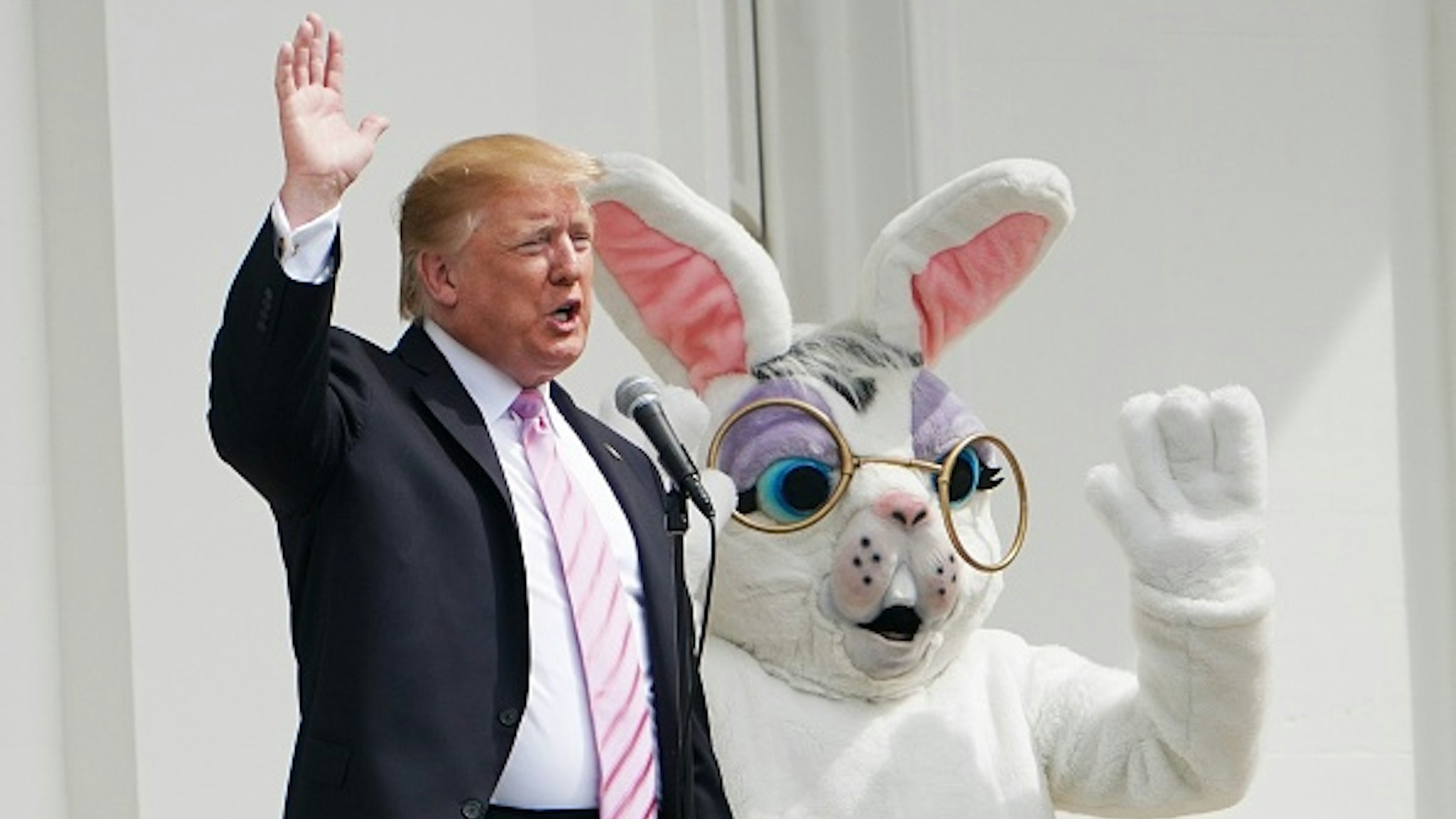 TOPSHOT - US President Donald Trump and the Easter Bunny wave during the annual White House Easter Egg Roll on the South Lawn of the White House in Washington, DC on April 22, 2019.