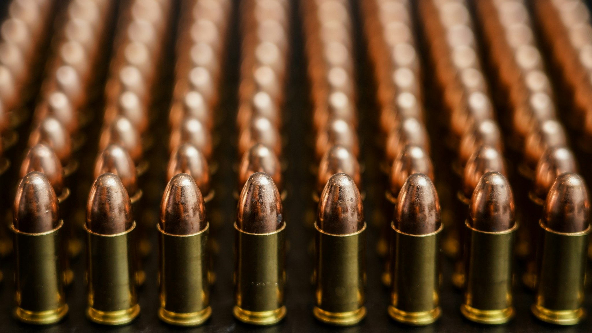 Many bullets or ammunition standing in straight line with blurred background. 9mm