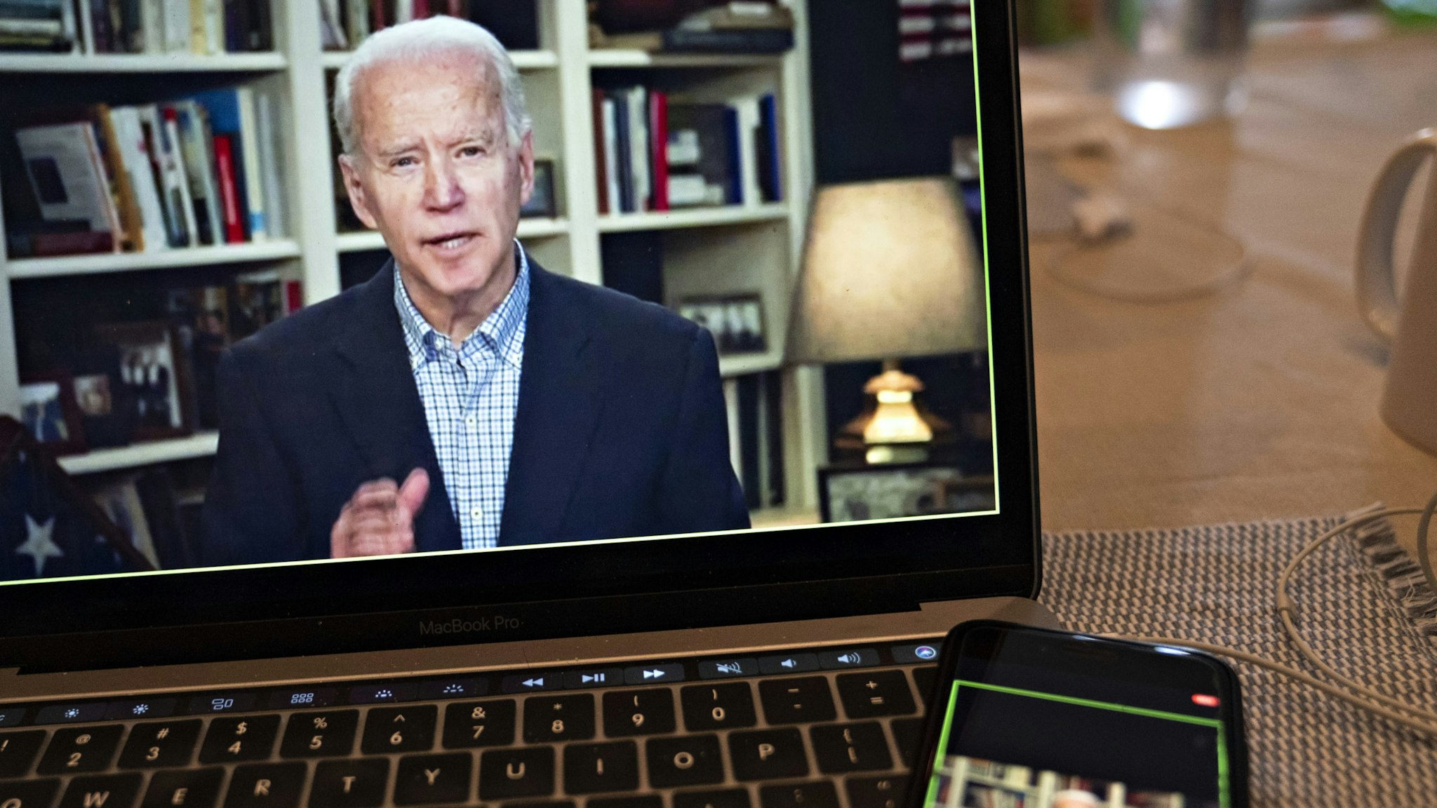 Former Vice President Joe Biden, 2020 Democratic presidential candidate, speaks during a virtual press briefing on a laptop computer in this arranged photograph in Arlington, Virginia, U.S., on Wednesday, March 25, 2020. During the livestreamed news conference today, Biden said he didn't see the need for another debate, which the Democratic National Committee had previously said would happen sometime in April. Photographer: Andrew Harrer/Bloomberg via Getty Images