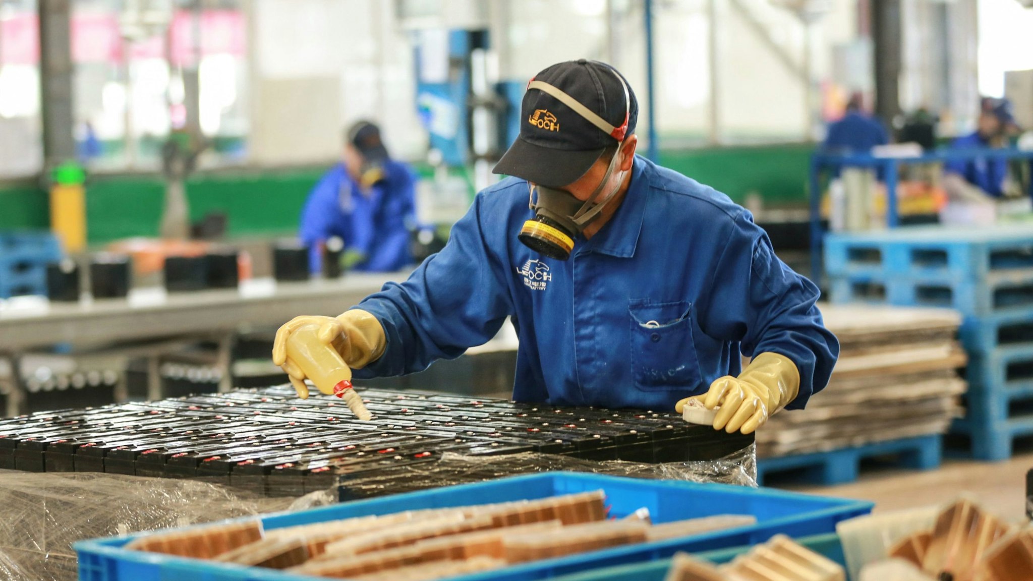 This photo taken on March 30, 2020 shows employees working on a battery production line at a factory in Huaibei in China's eastern Anhui province. - Factory activity in China rebounded in March from a record low, according to official data released on March 31, returning to expansion territory while the coronavirus pandemic continues to devastate the global economy. (Photo by STR / AFP) / China OUT (Photo by STR/AFP via Getty Images)
