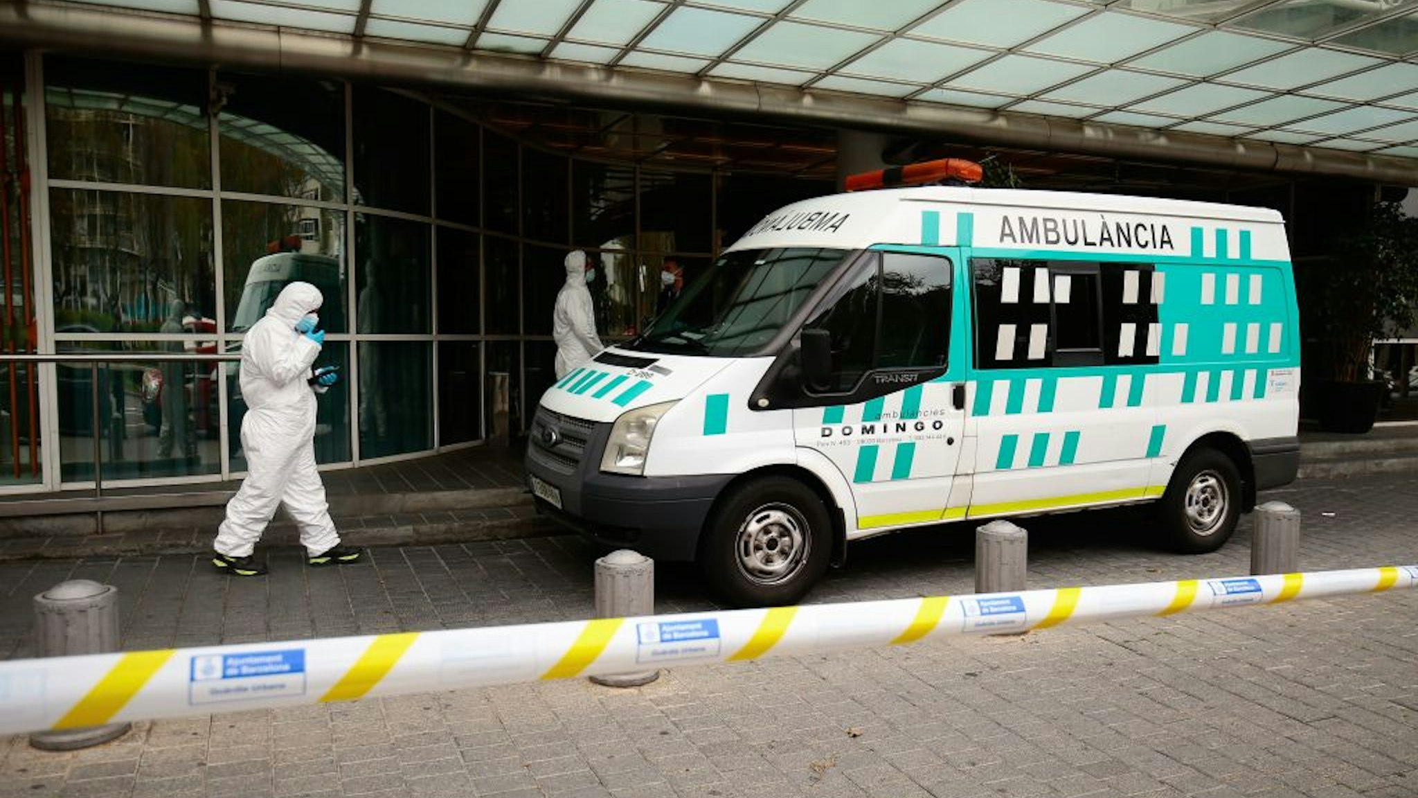 Healthcare workers wearing protective suits enter an ambulance in front of the Hotel Melia Barcelona Sarria on April 2, 2020 in Barcelona, as the hotel was transformed into a medical structure to treat the least serious cases amid the outbreak caused by the novel coronavirus.