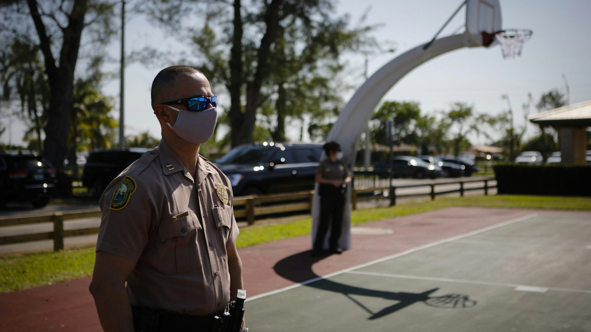 A police officer wears a protective mask while listening to Carlos Gimenez, mayor of Miami-Dade County, not pictured, speak during a news conference in Miami, Florida, U.S., on Monday, April 27, 2020. On Wednesday Miami-Dade's six-week closure order for parks will officially end, replaced by a new set of rules aimed at limiting close encounters during the coronavirus pandemic, according to the Miami Herald. Photographer: Eva Marie Uzcategui/Bloomberg via Getty Images