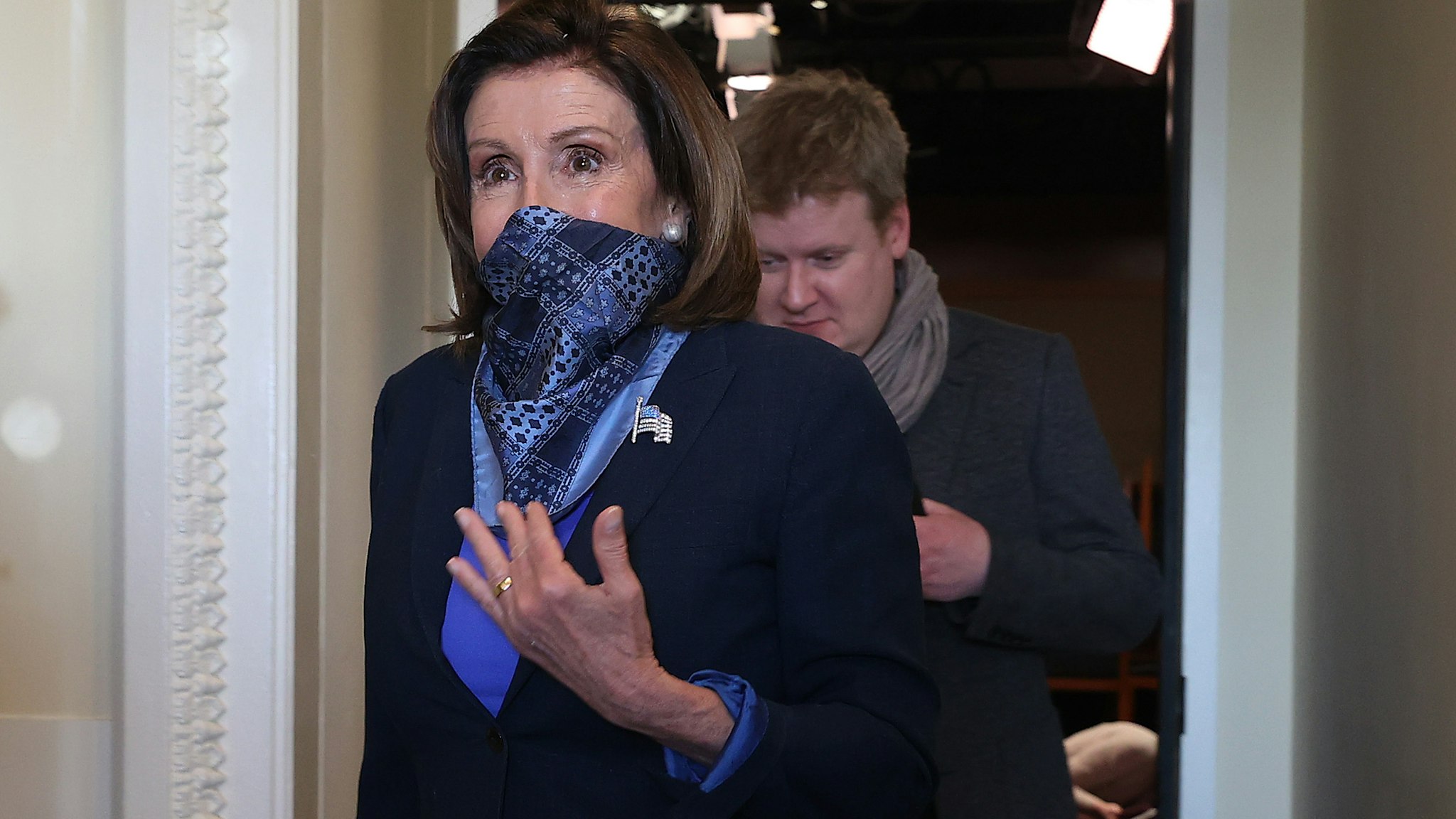 WASHINGTON, DC - APRIL 21: House Speaker Nancy Pelosi (D-CA) wears a scarf over her mouth and nose to guard against the coronavirus as she and and her Deputy Chief of Staff Drew Hammill leave a news conference with Minority Leader Charles Schumer (D-NY) at the U.S. Capitol April 21, 2020 in Washington, DC. Pelosi, Schumer and Senate Majority Leader Mitch McConnell (R-KY) agreed on new $500 billion bipartisan deal to deliver more coronavirus relief to small businesses and hospitals. (Photo by Chip Somodevilla/Getty Images)