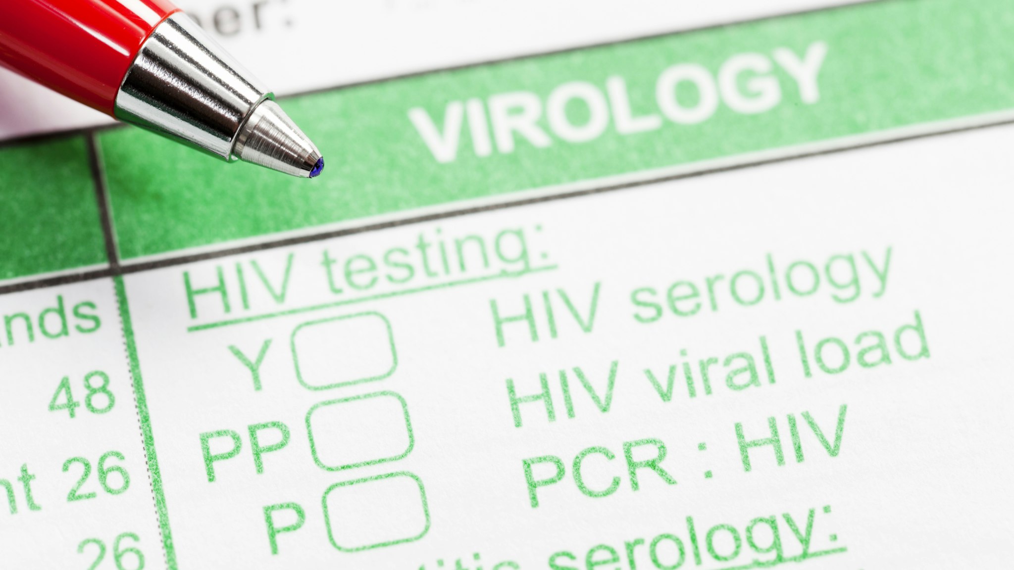 Red pen on virology form ordering HIV tests - stock photo